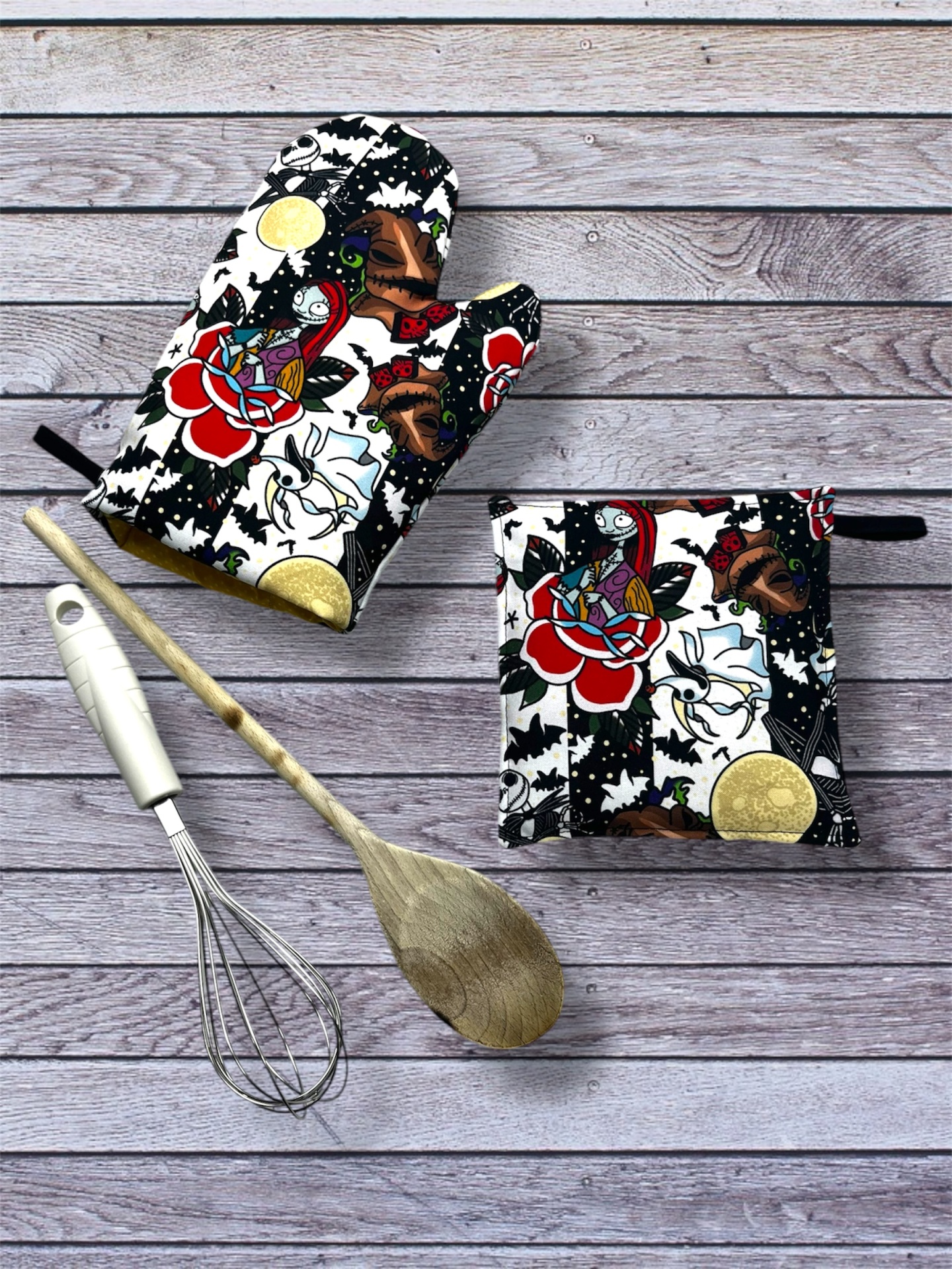 manopla e pega de cozinha com padrão colorido e utensílios de cozinha sobre madeira