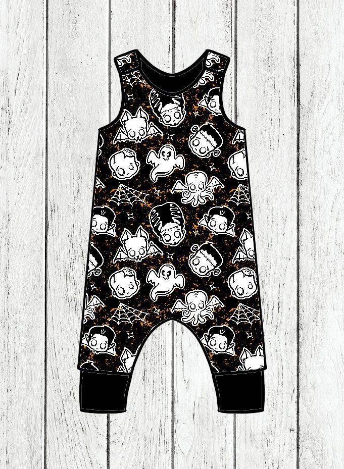 Macacão de criança preto com desenhos de Halloween brancos sobre fundo de madeira