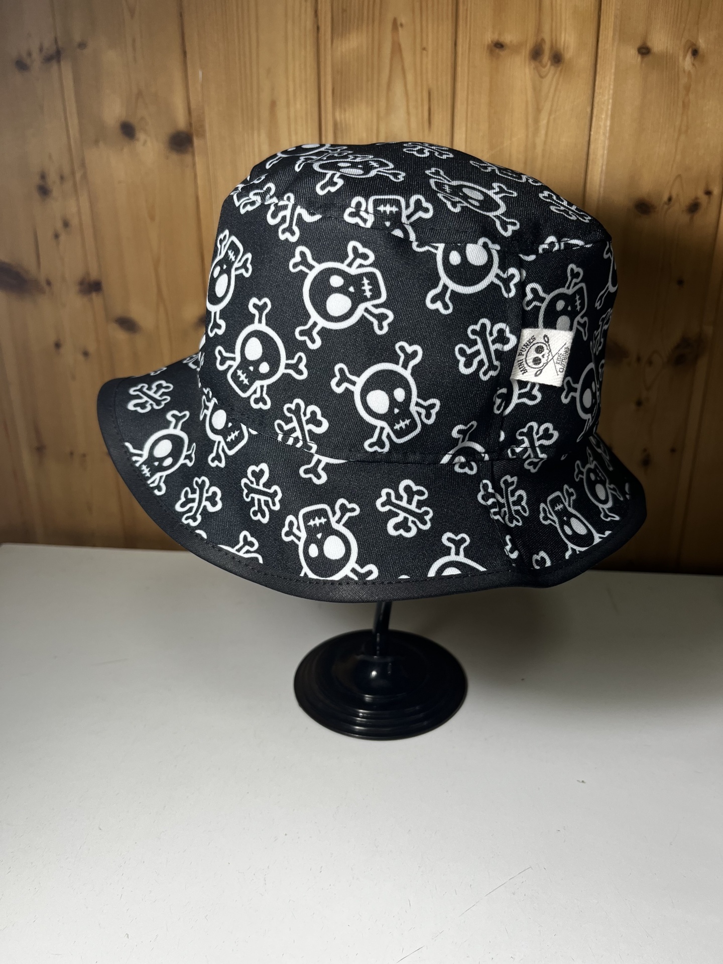 Chapéu bucket preto com padrão de caveiras brancas