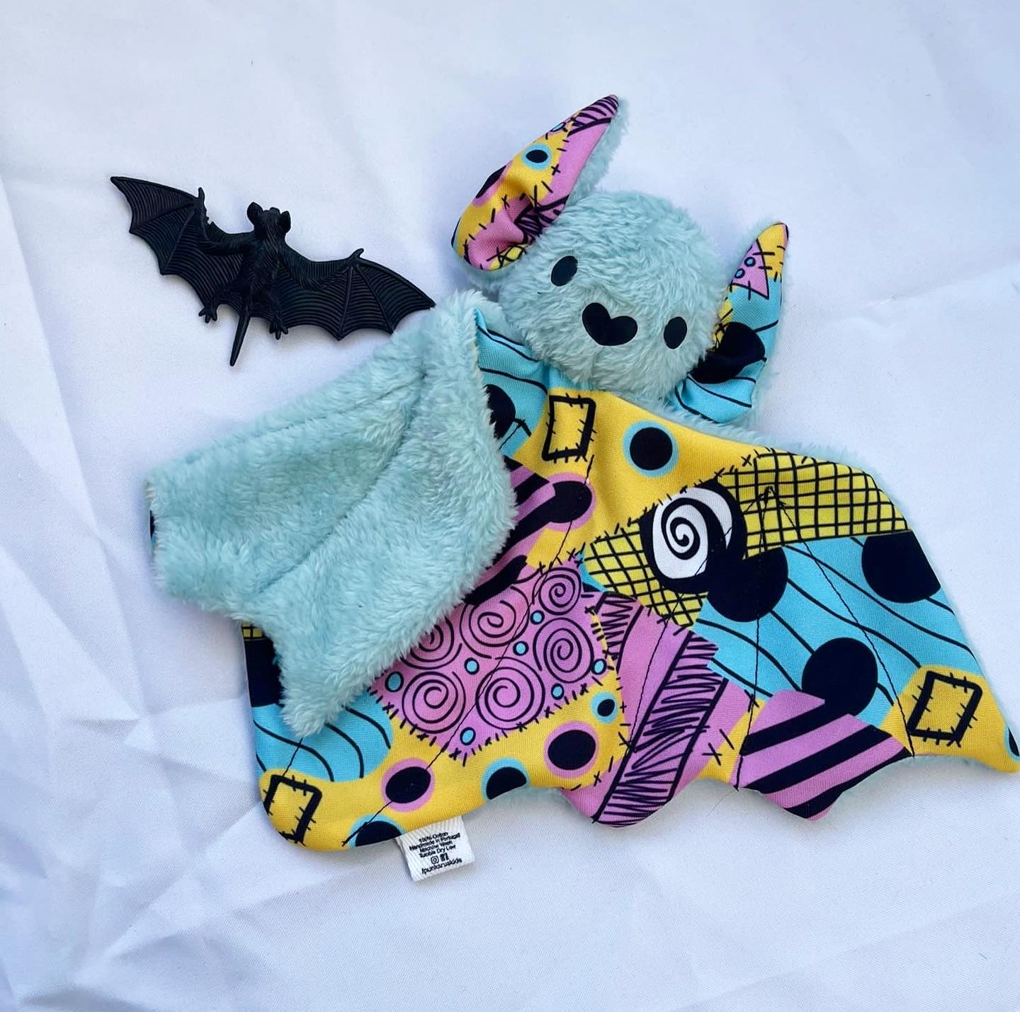 Brinquedo de peluche em forma de morcego e morcego preto de plástico ao lado