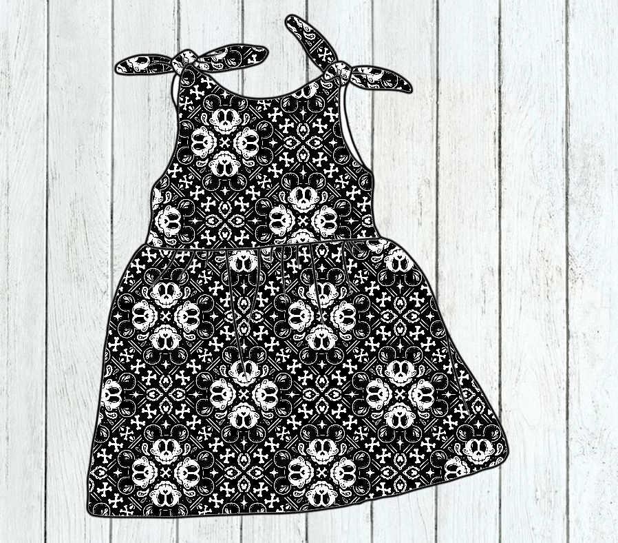 Vestido infantil preto com padrão branco de caveiras e cruzes