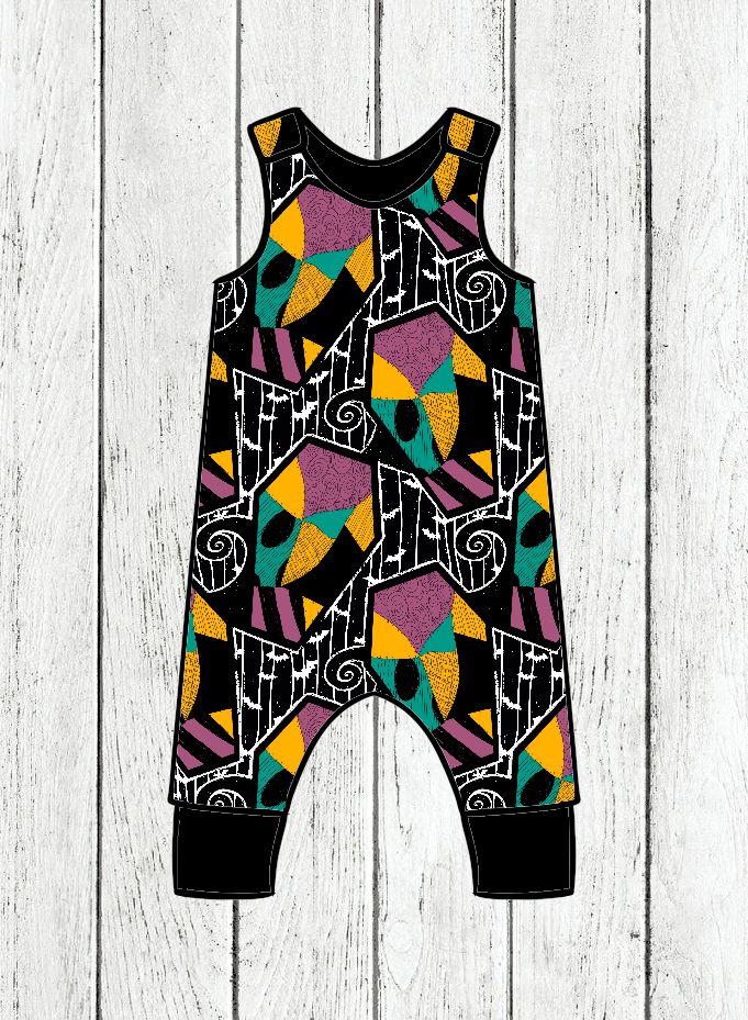 Macacão infantil colorido com padrão geométrico sobre fundo de madeira branca