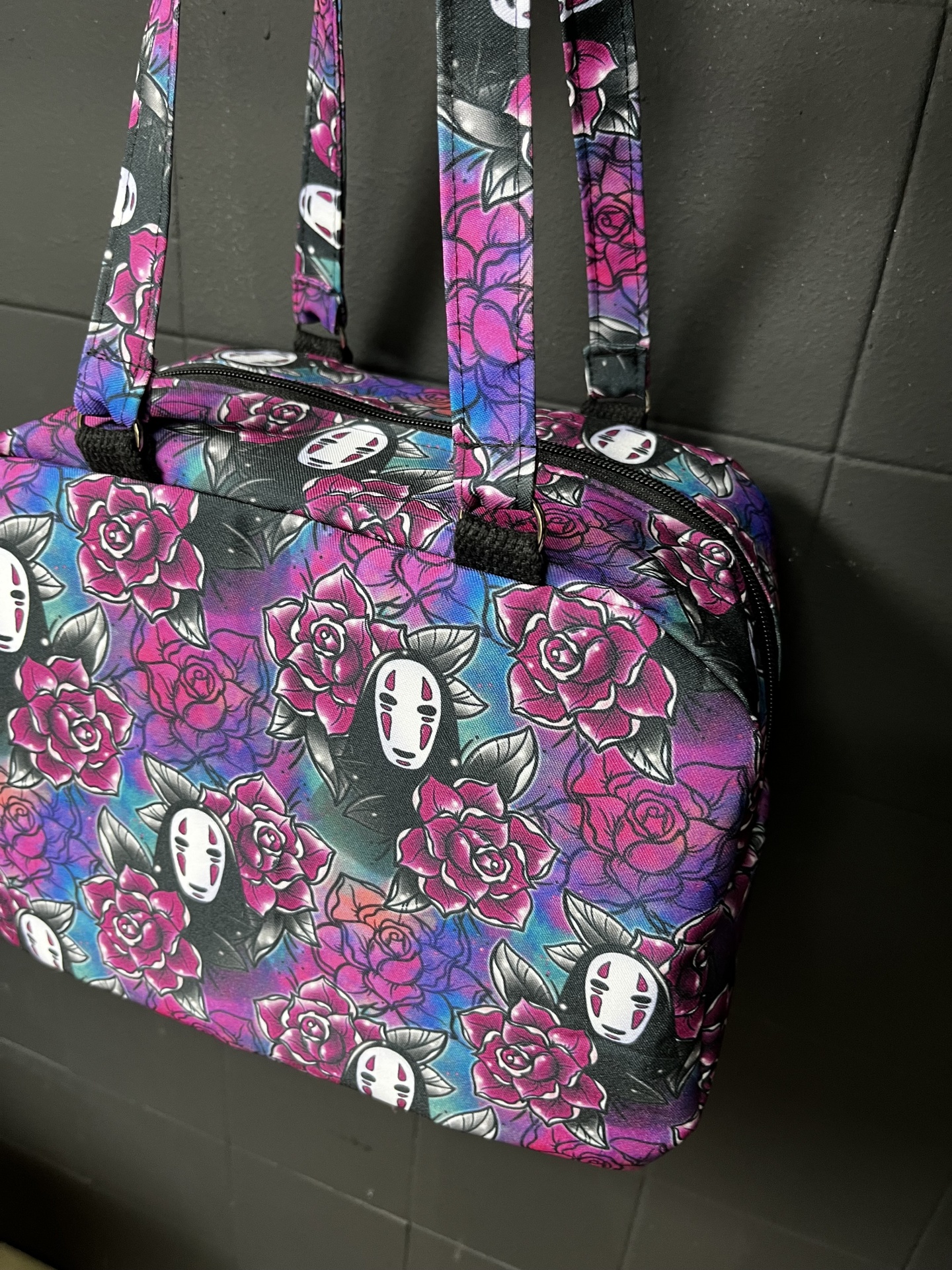 Mala colorida com padrão de flores e máscaras brancas em tecido sintético