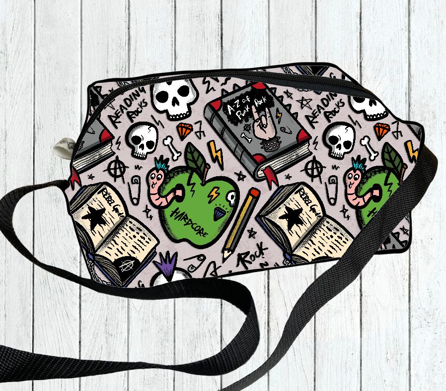 Mala de ombro com padrão colorido de caveiras, livros e corações em fundo cinza