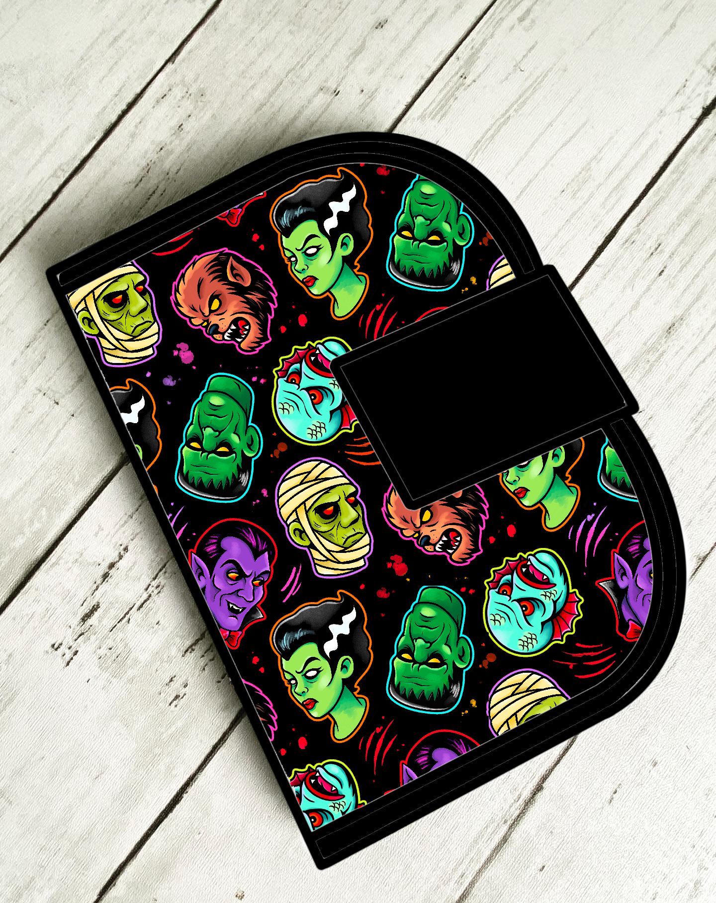 Protector de forno com padrão colorido de monstros clássicos em fundo preto