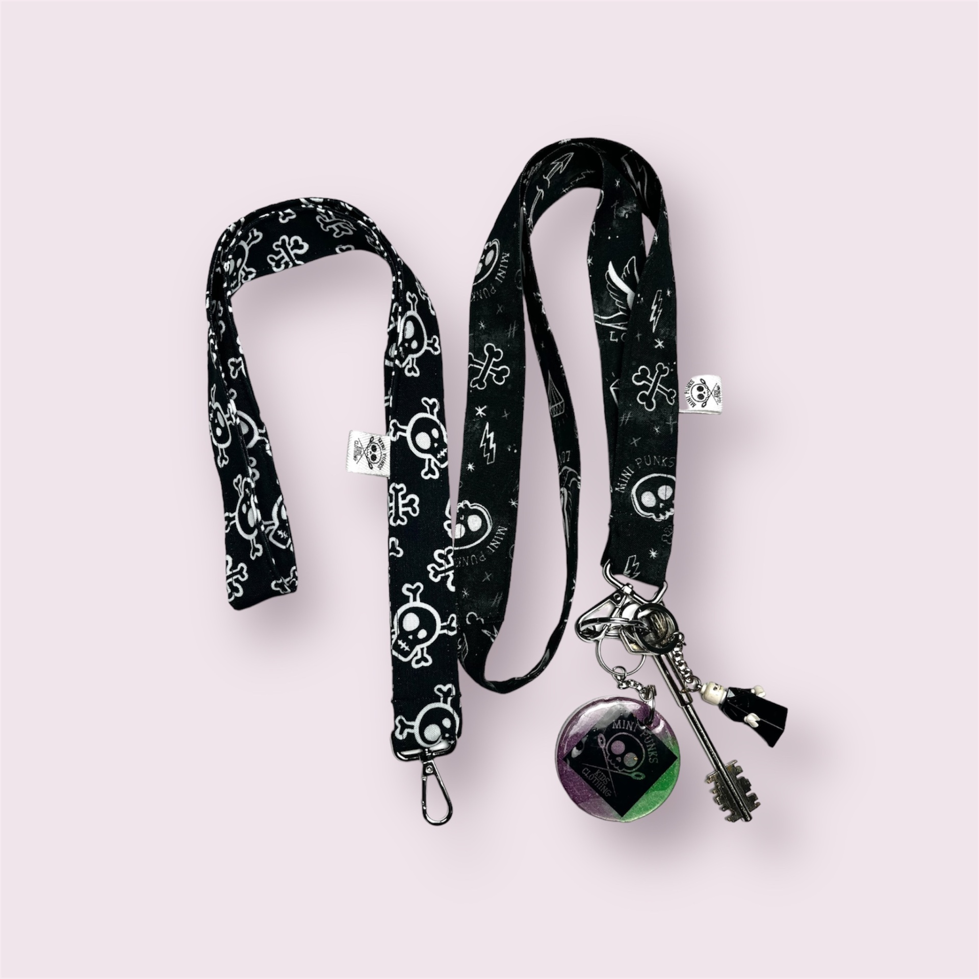 Cordão preto estampado com caveiras e flores, chaveiro com esfera colorida e chaves