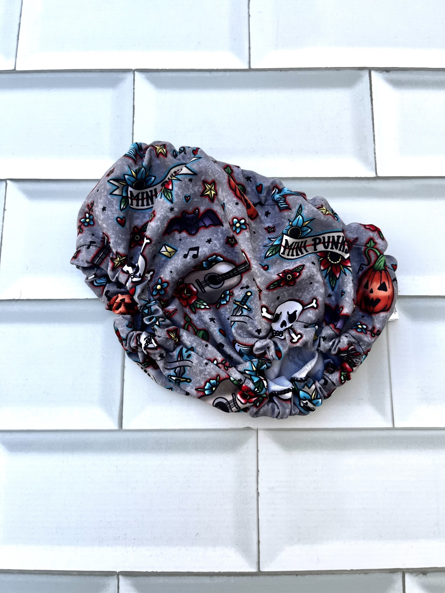 Touca ou faixa de cabelo com estampado colorido e fundo cinzento