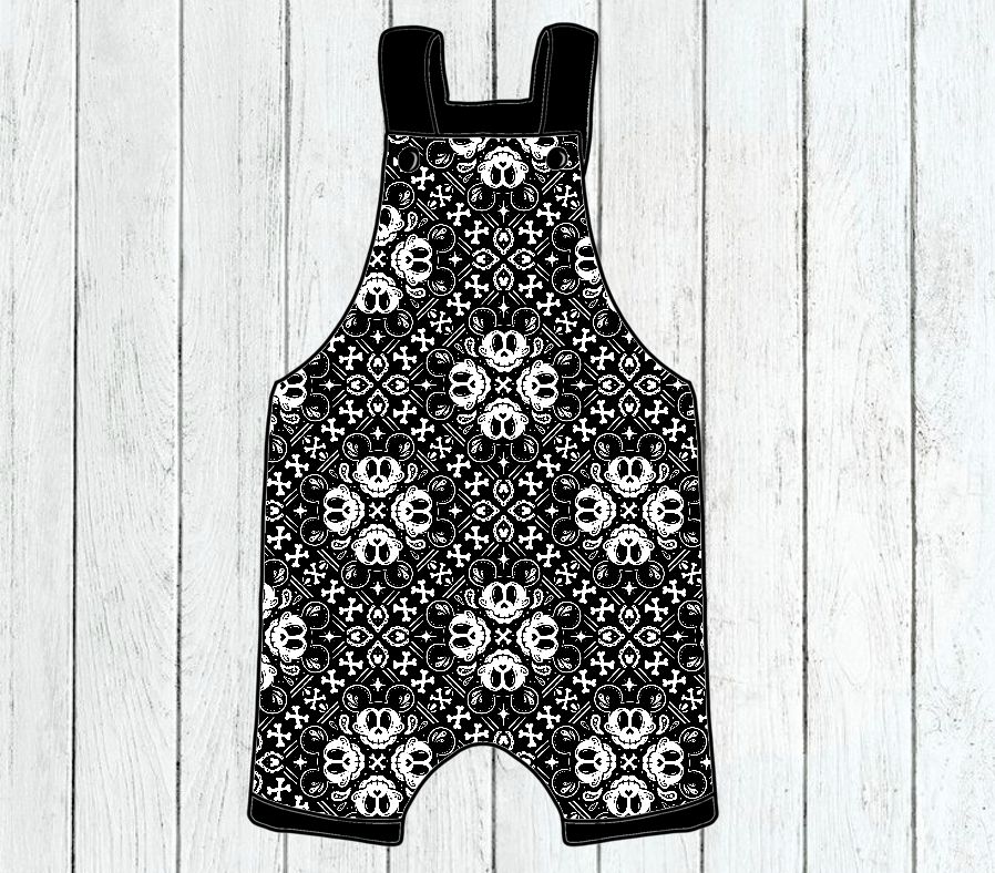 Macacão curto preto e branco com padrão repetido de personagens animadas contra fundo de madeira clara