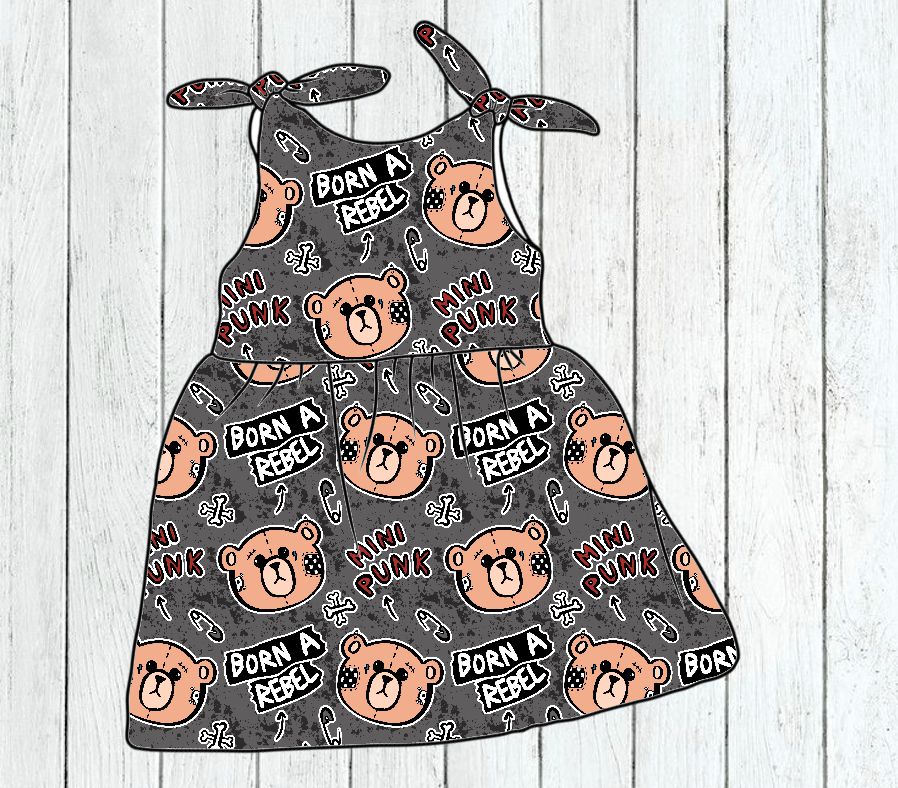 Vestido cinzento para criança com padrão de ursos e texto BORN A REBEL e MINI PUNK em fundo de madeira clara