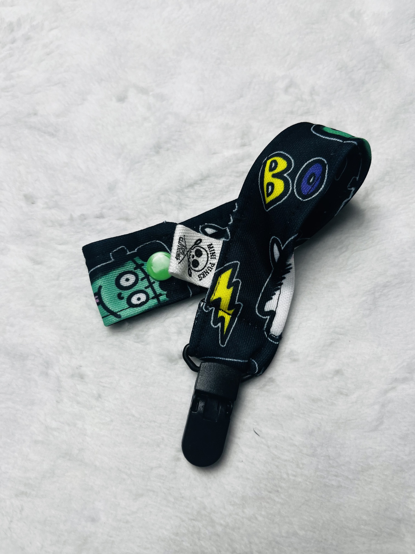 correia de tecido preta com estampados de monstros, relâmpagos e texto BOO