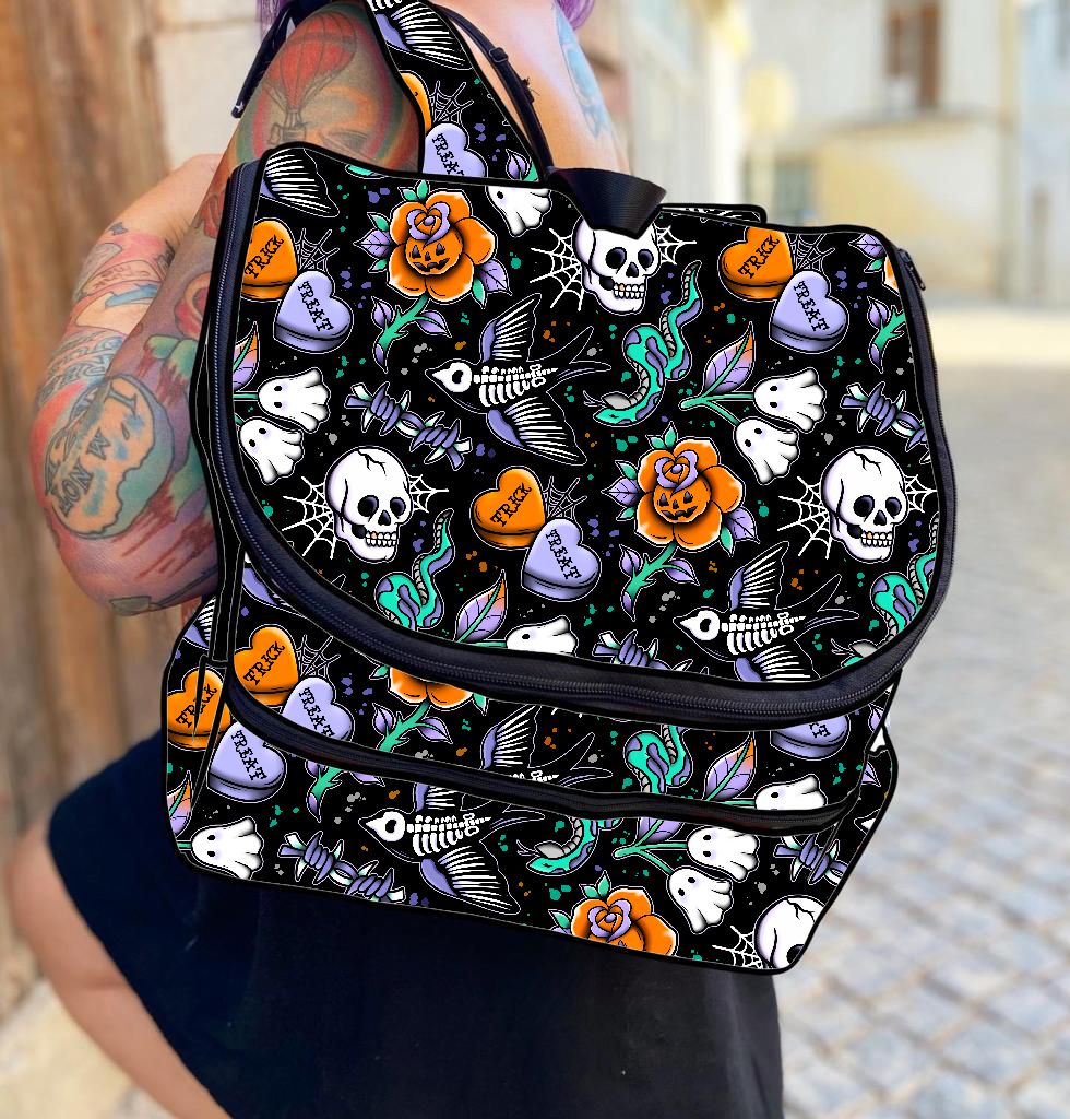 Mochila preta com padrão colorido de caveiras, corações e flores usados por pessoa tatuada
