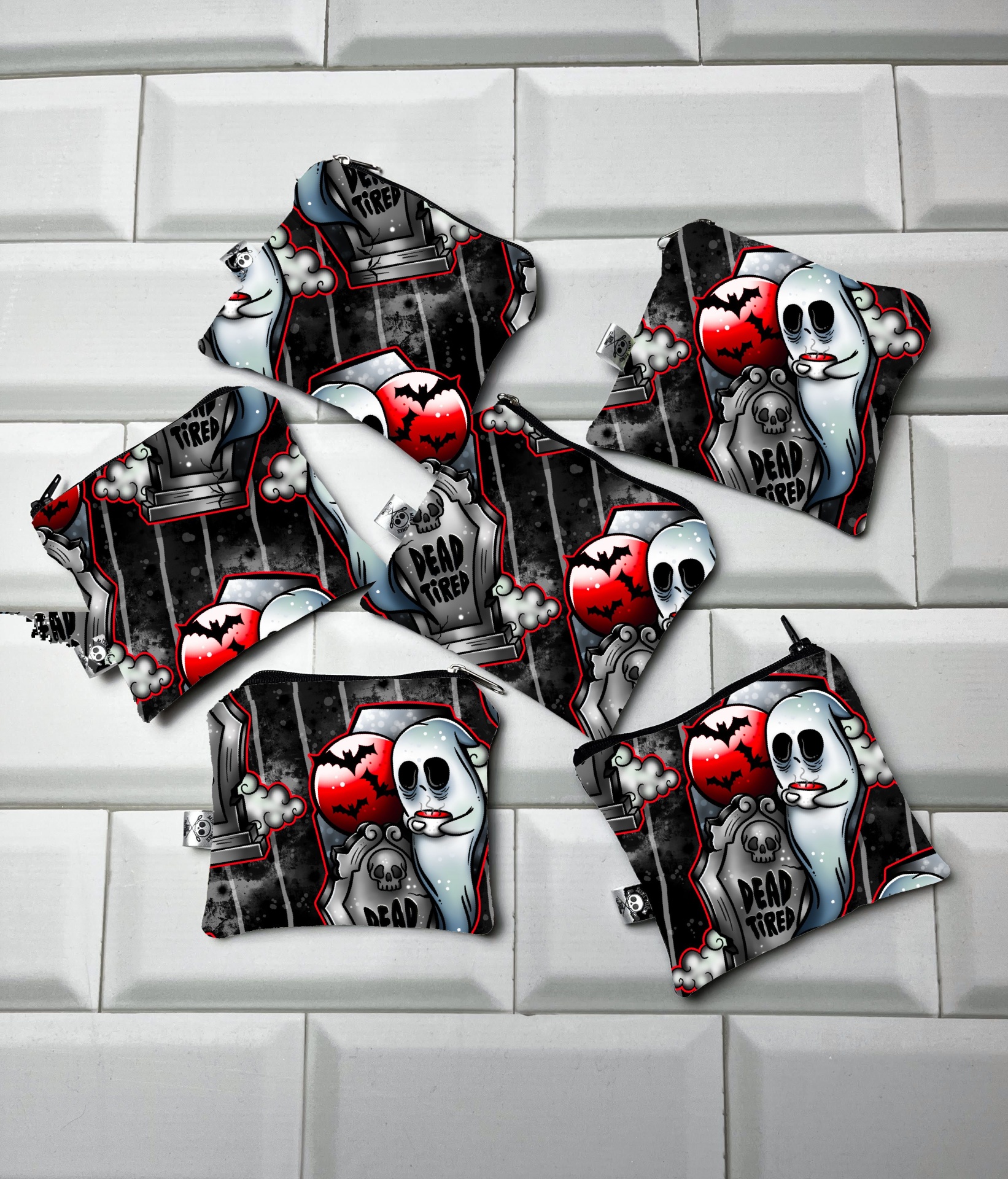 Roupas infantis com padrão de fantasmas e texto 'DEAD TIRED'