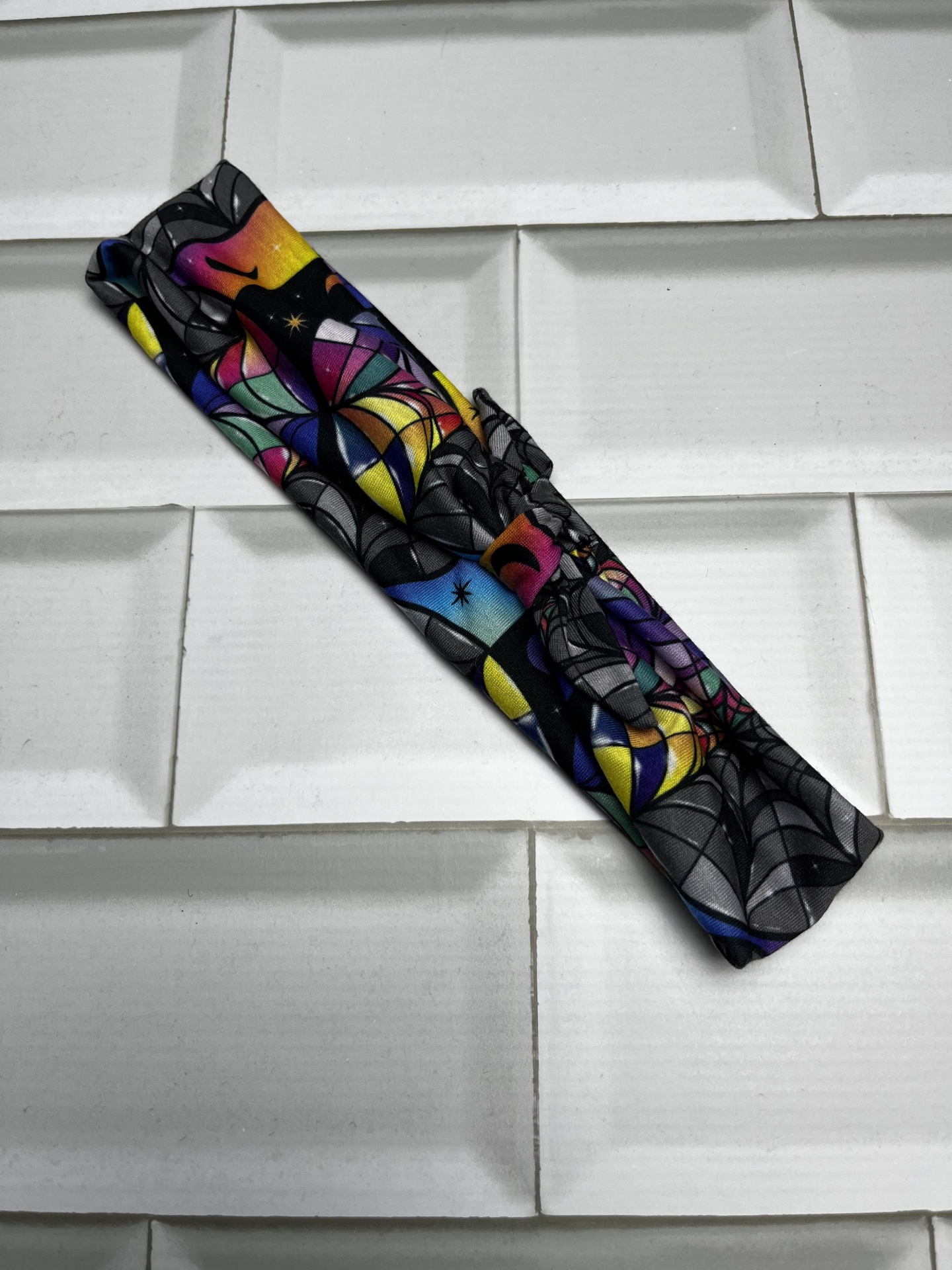 Fita de tecido colorida com padrão abstrato enrolada sobre superfície branca texturizada