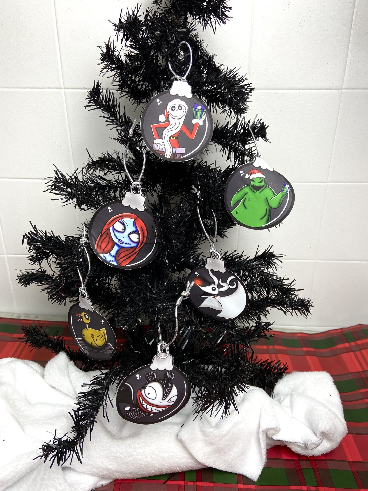 Árvore de Natal preta com bolas decorativas com personagens animados coloridos.