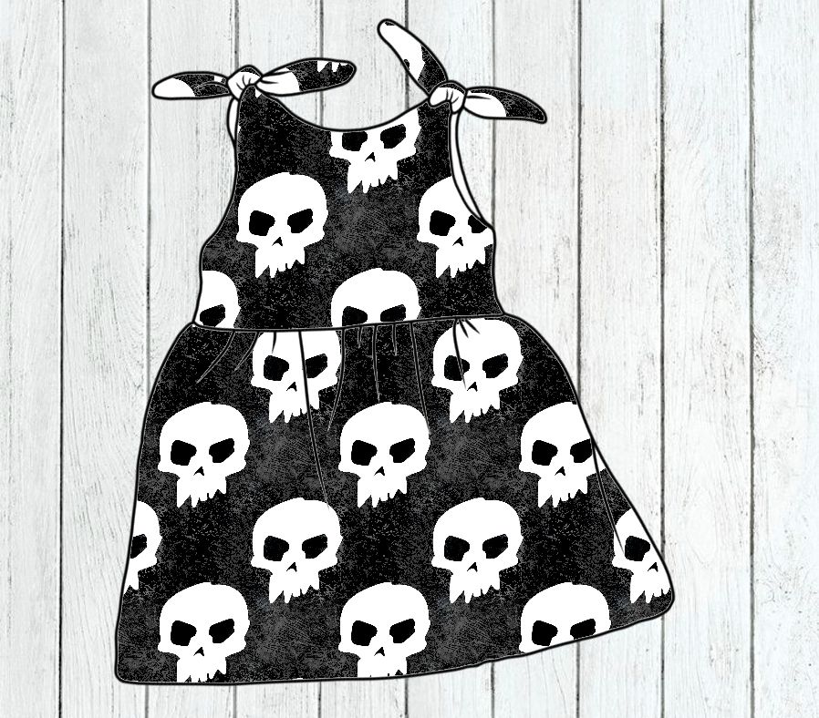 Vestido infantil preto com padrão de caveiras brancas e alças para amarrar