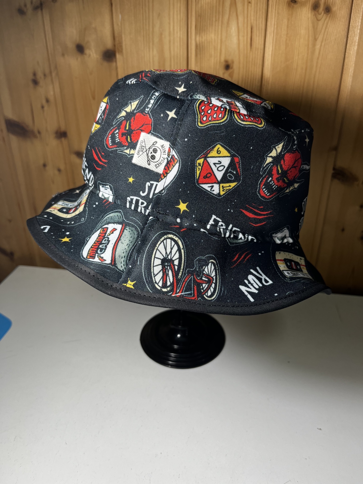 Chapéu bucket preto com várias estampas coloridas e etiqueta branca com selo de caveira