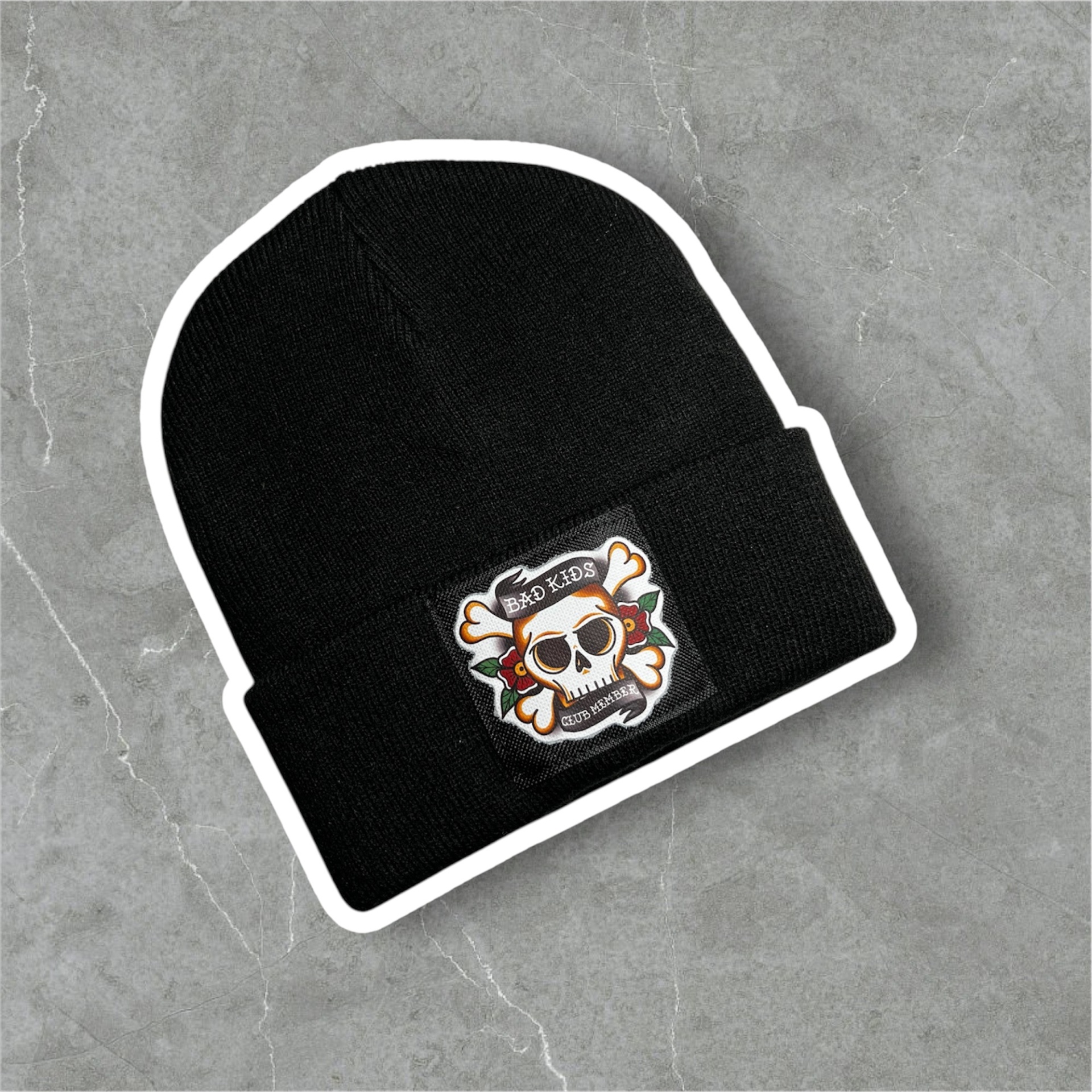 Gorro preto de malha com emblema frontal de crânio cartoon e texto