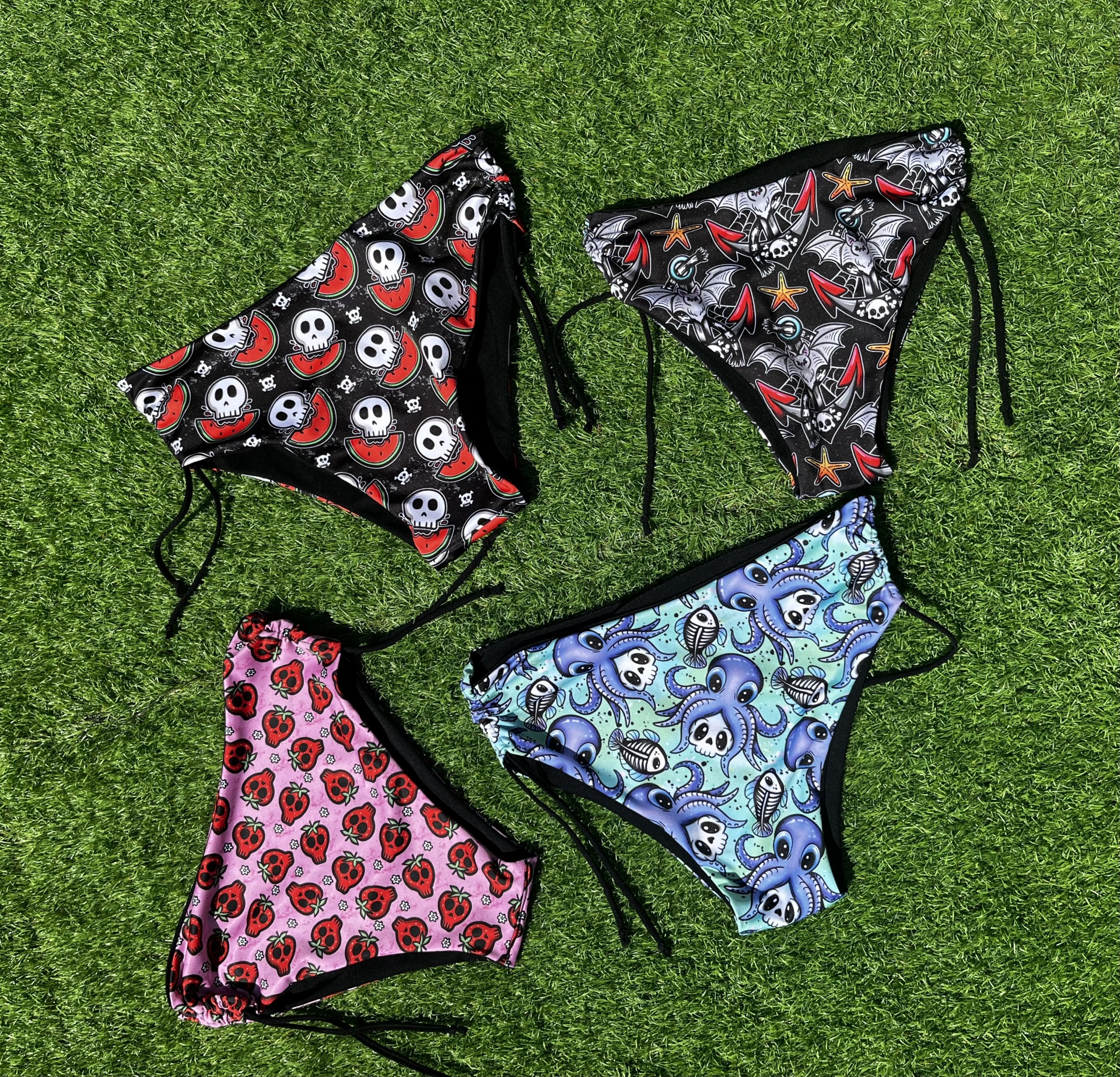 Quatro peças de roupa interior femininas coloridas com padrões variados sobre relva artificial