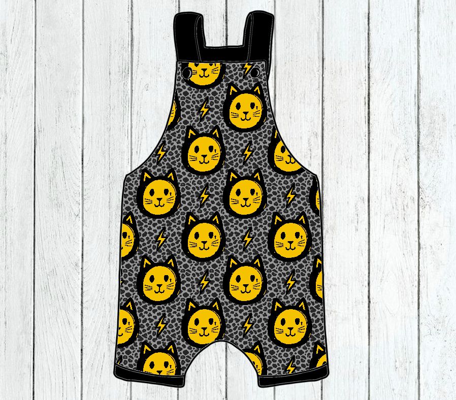 Jardineira infantil cinzenta com padrão amarelo de gatos e símbolos de relâmpagos