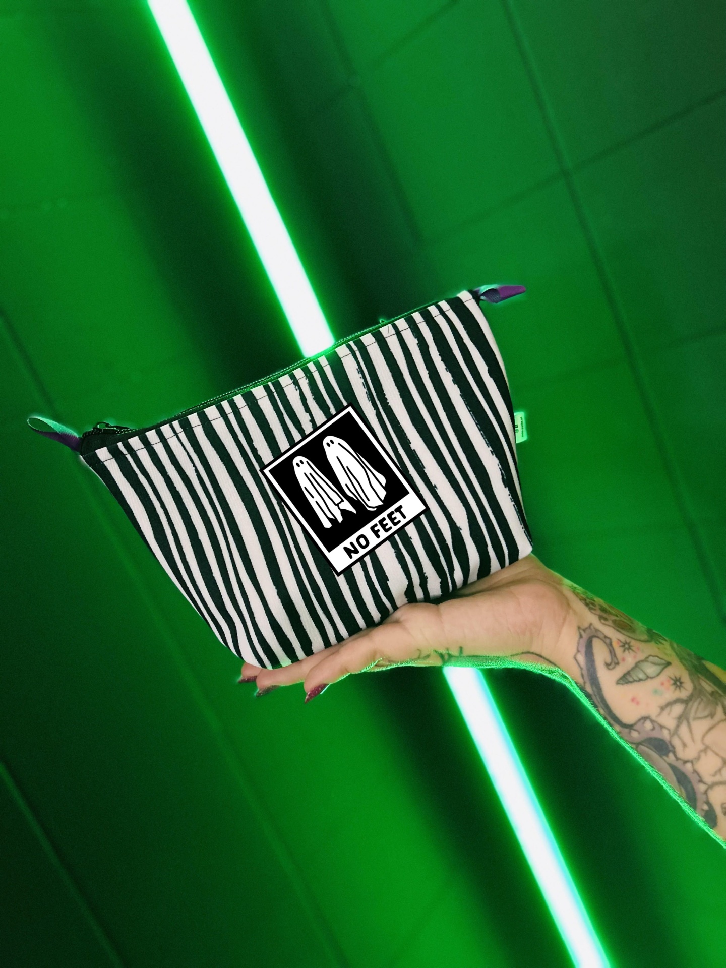 Bolsa pequena riscas pretas e brancas com patch NO FEET em fundo verde