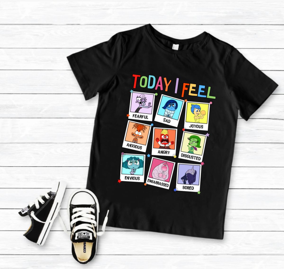 T-shirt preta com estampado colorido de nove emoções e ténis pretos e brancos ao lado