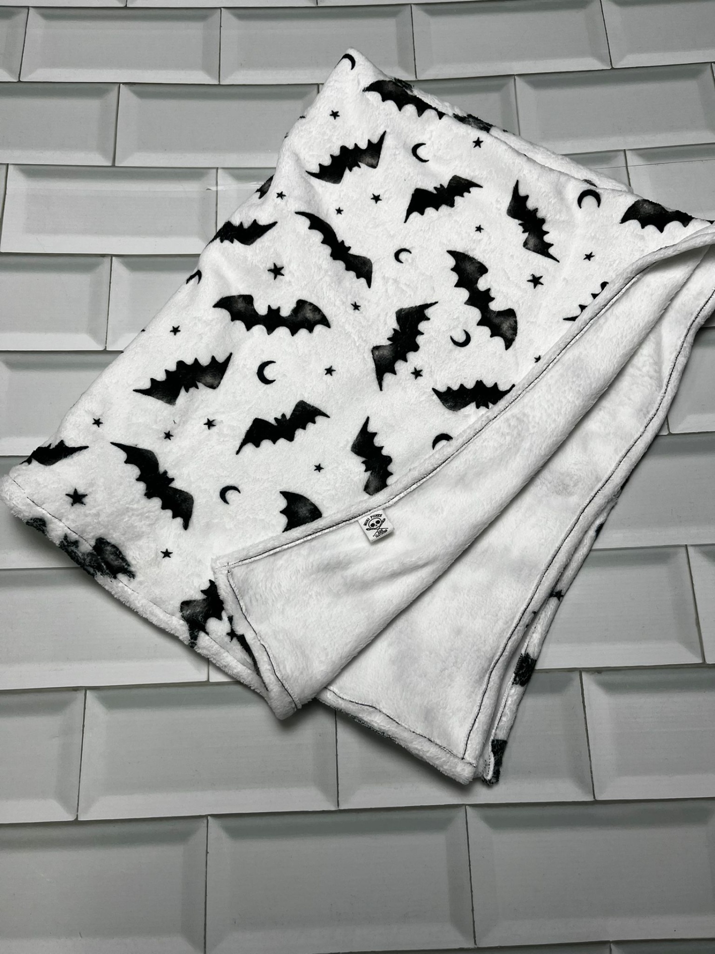 Manta felpuda branca com morcegos pretos e estrelas