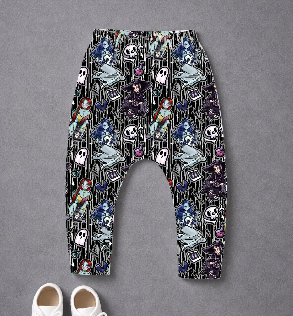 Calças de criança com padrão gótico colorido e sapatos brancos no chão cinzento