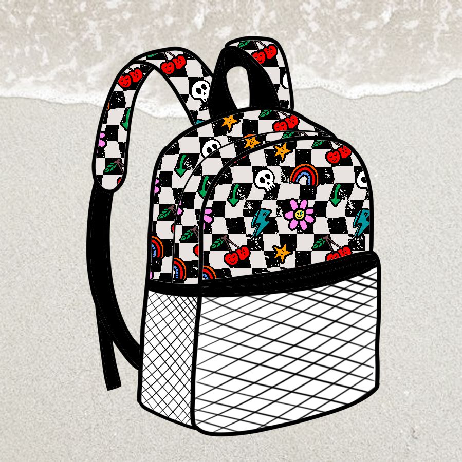 Mochila xadrez preto e branco com desenhos coloridos e bolso frontal texturizado, sobre areia e mar.