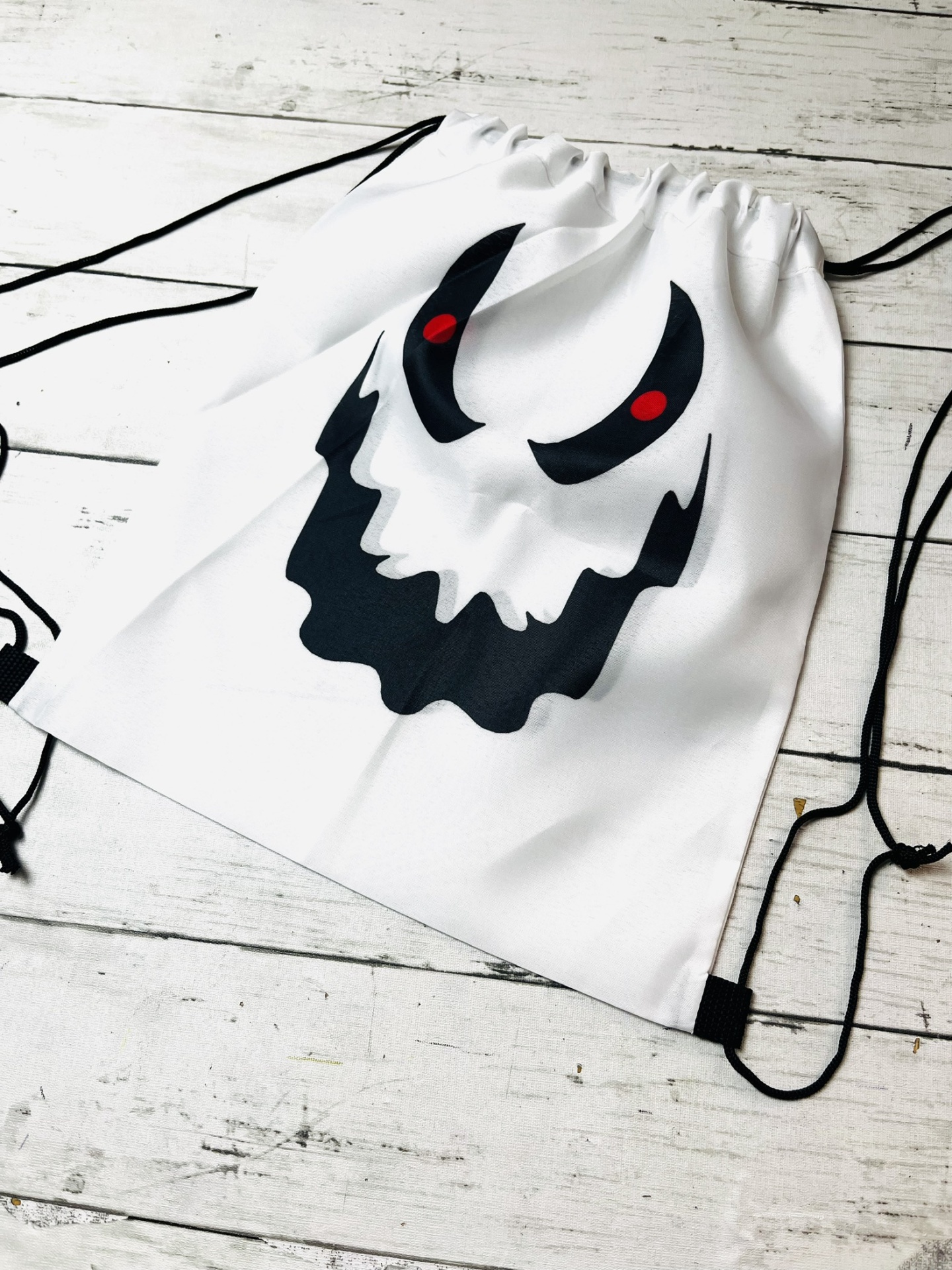 Mochila saco branca com estampa de rosto preto e vermelho