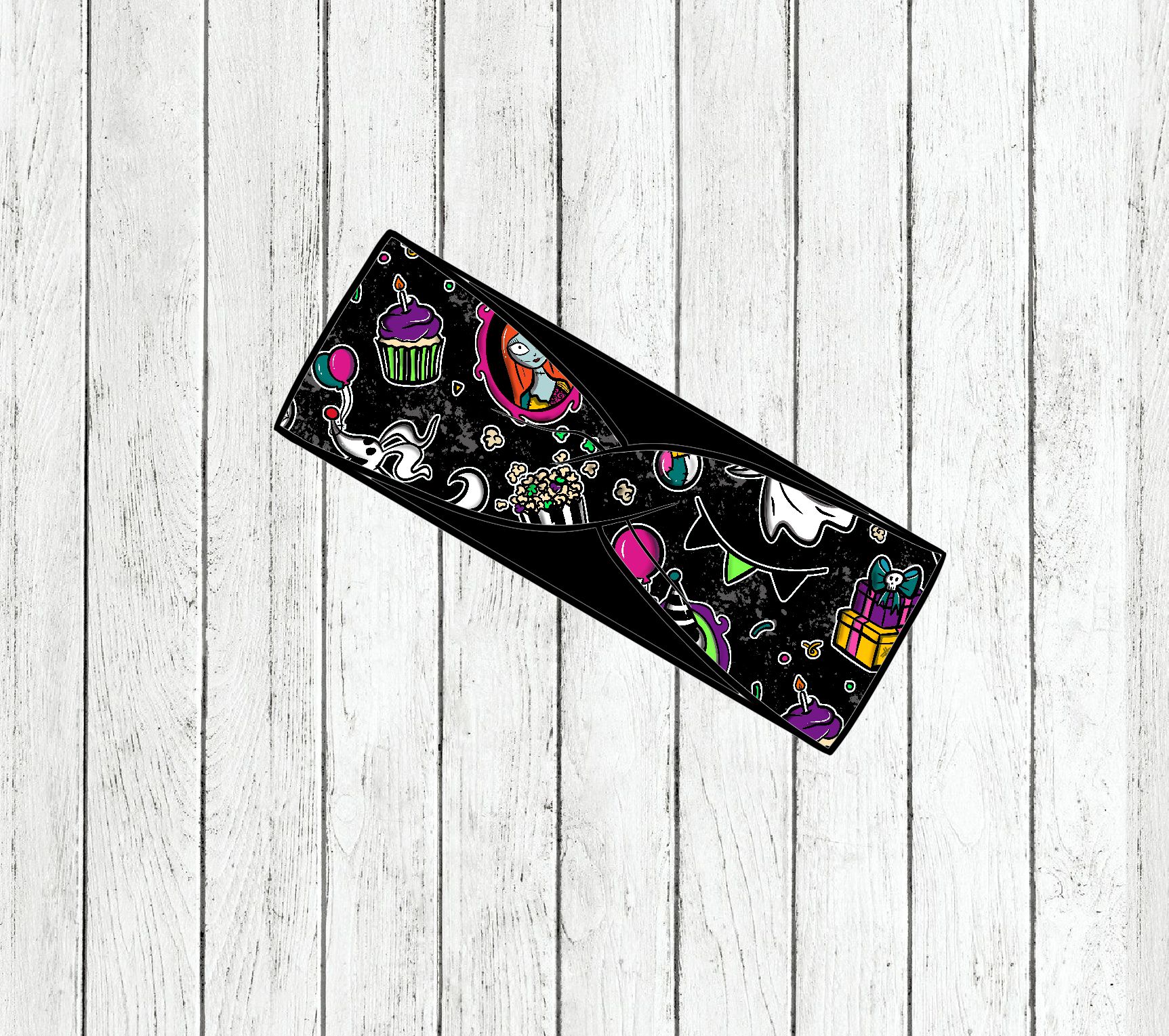 Faixa preta com desenhos coloridos festivos sobre fundo de madeira branca desgastada.