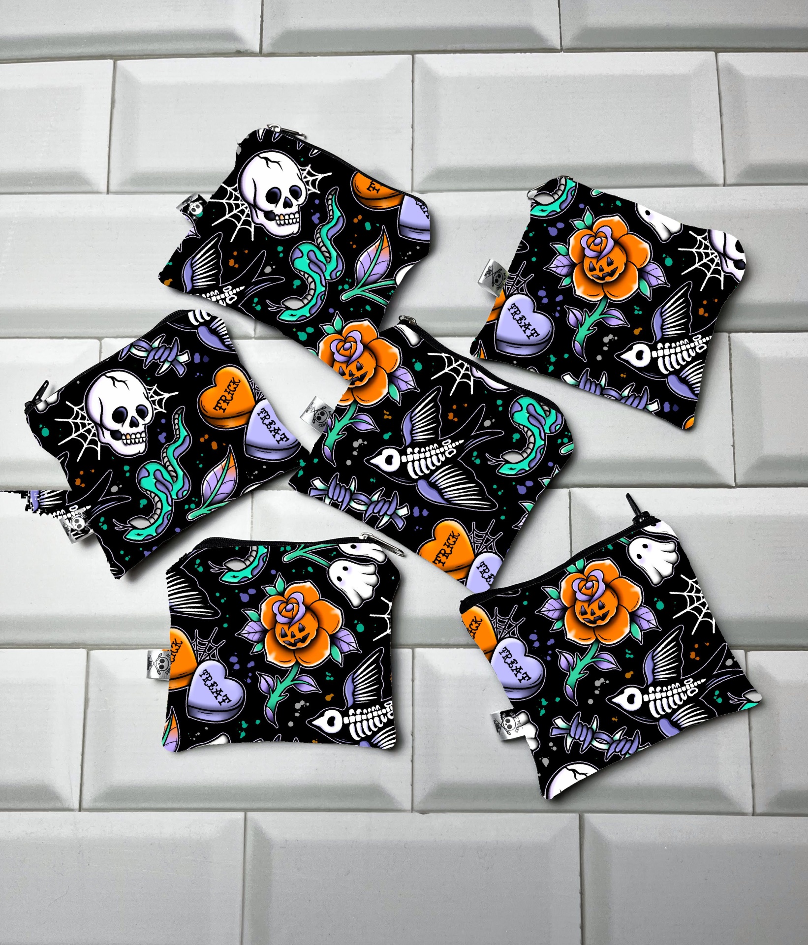 Seis saquinhos de tecido com padrão colorido místico em fundo preto sobre azulejos brancos