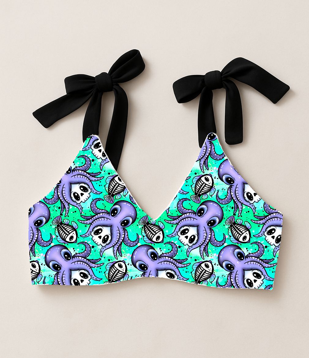 Top de biquíni colorido com padrão de polvo roxo, caveiras e esqueletos de peixes, alças pretas para amarrar
