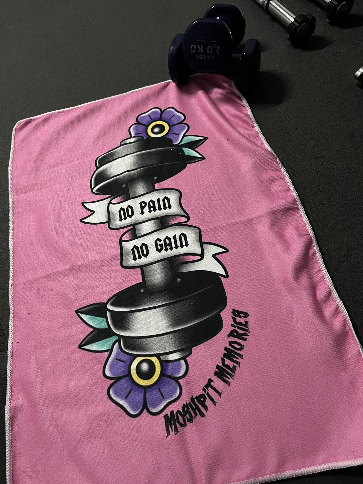 Toalha cor-de-rosa com haltere e texto motivacional pintados.