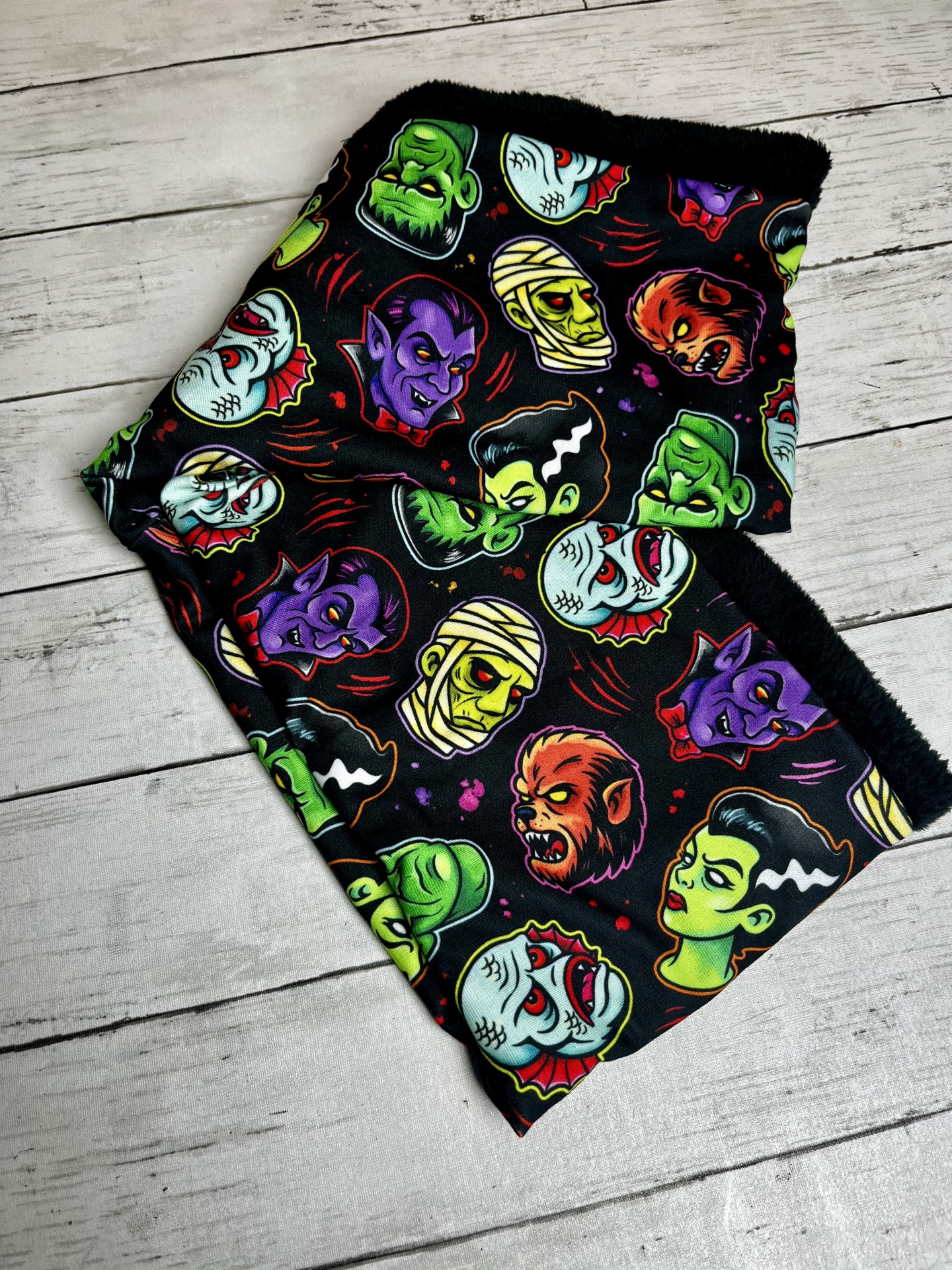 Lenço tubular com padrão colorido de monstros clássicos em fundo preto