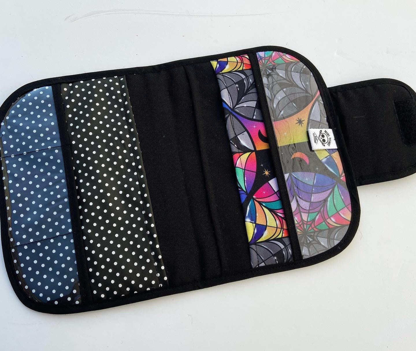 Estojo ou organizador com padrões coloridos e bolinhas, múltiplos compartimentos de tecido