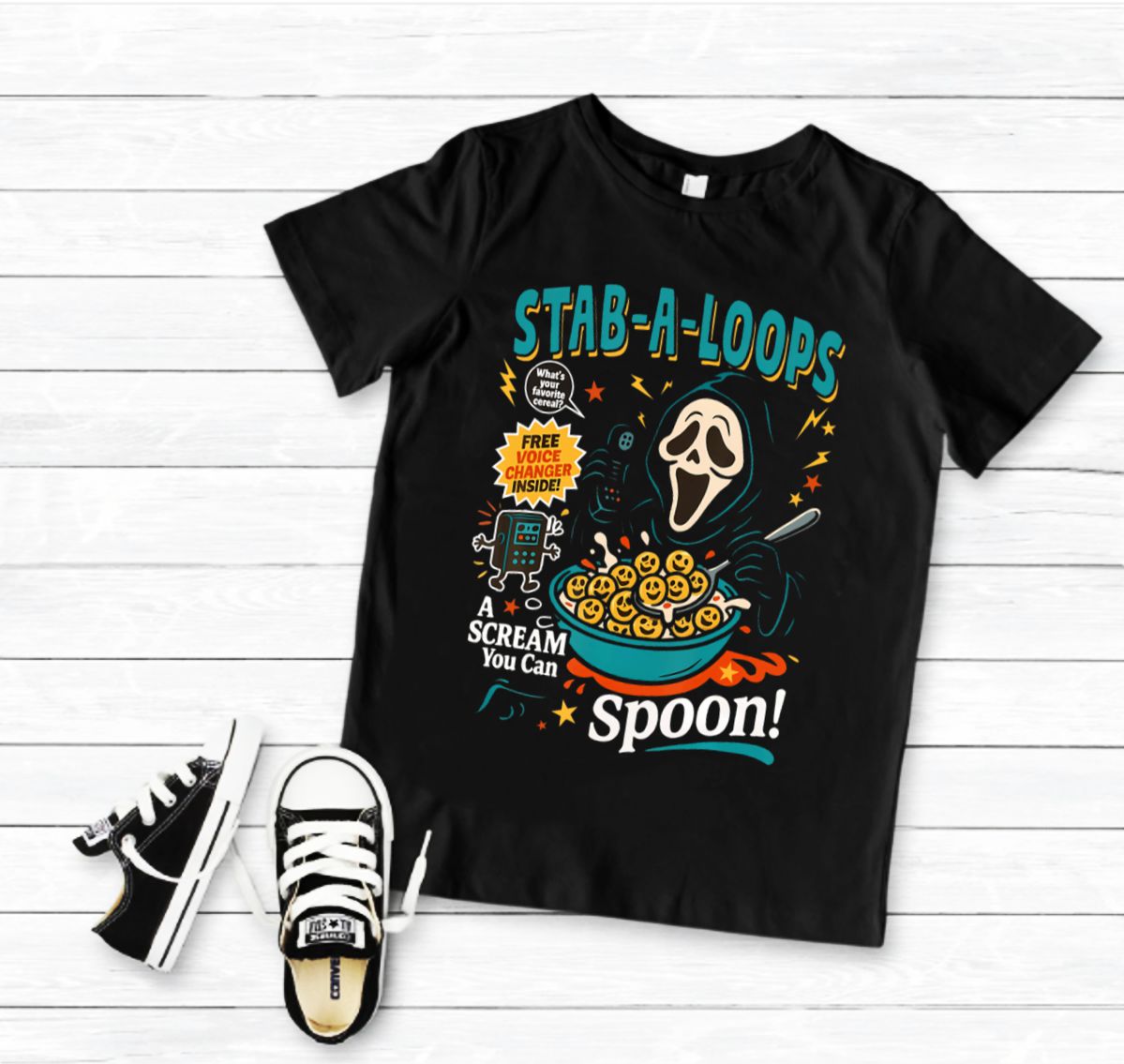 T-shirt preta com estampa colorida e ténis pretos e brancos ao lado