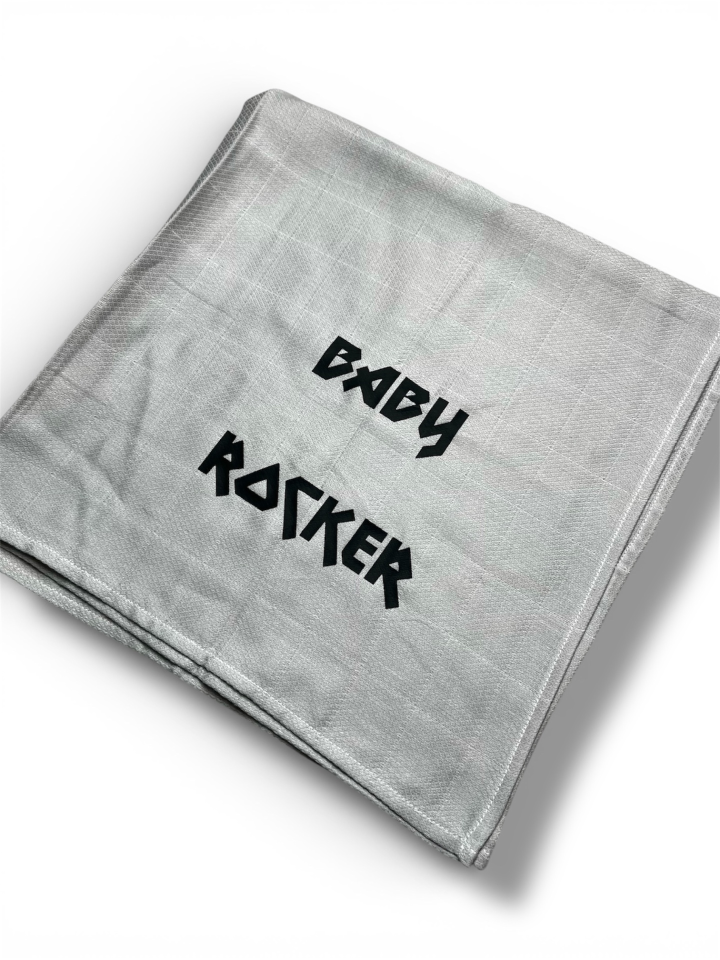 Manta cinza clara dobrada com texto preto BABY ROCKER