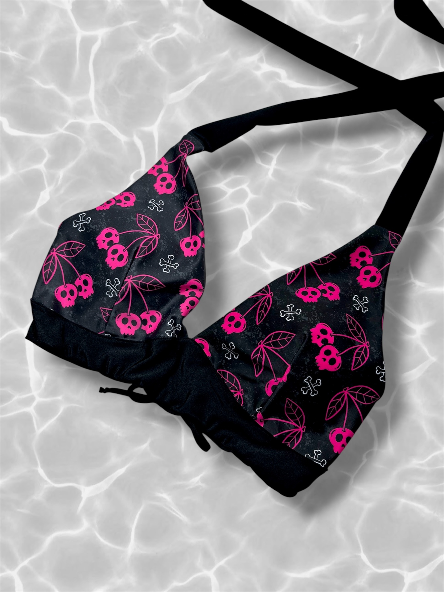 Top de bikini preto com padrão de cerejas em forma de caveira cor-de-rosa.