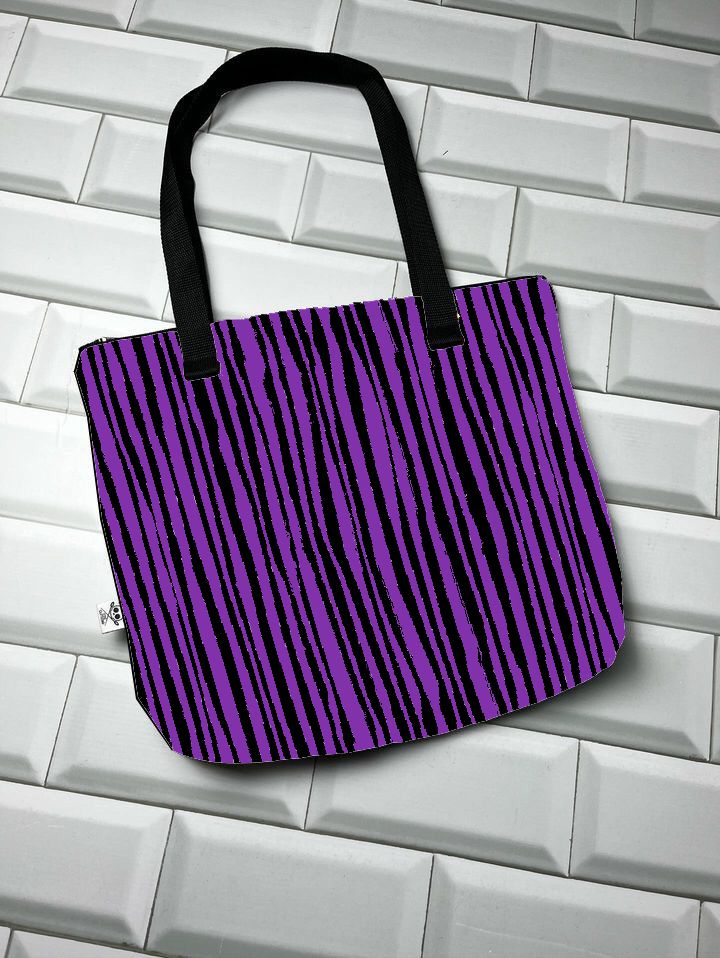 Saco roxo com riscas pretas e alças pretas sobre azulejos brancos.