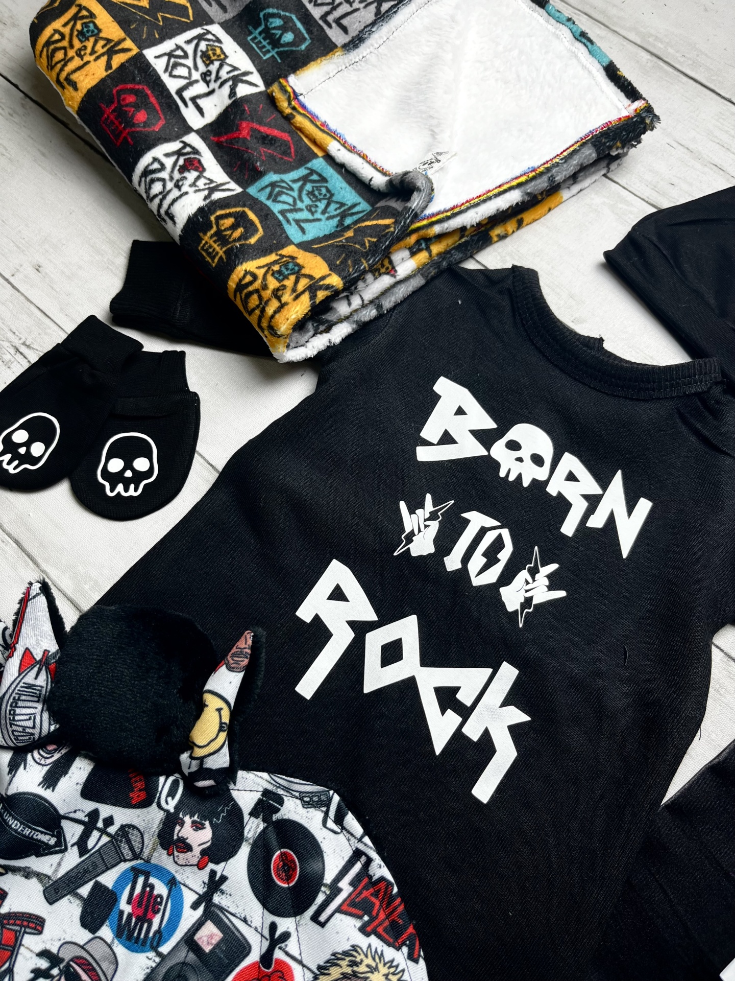 Roupa e acessórios de bebé com padrão Rock & Roll e caveiras em preto, branco, amarelo, vermelho e azul