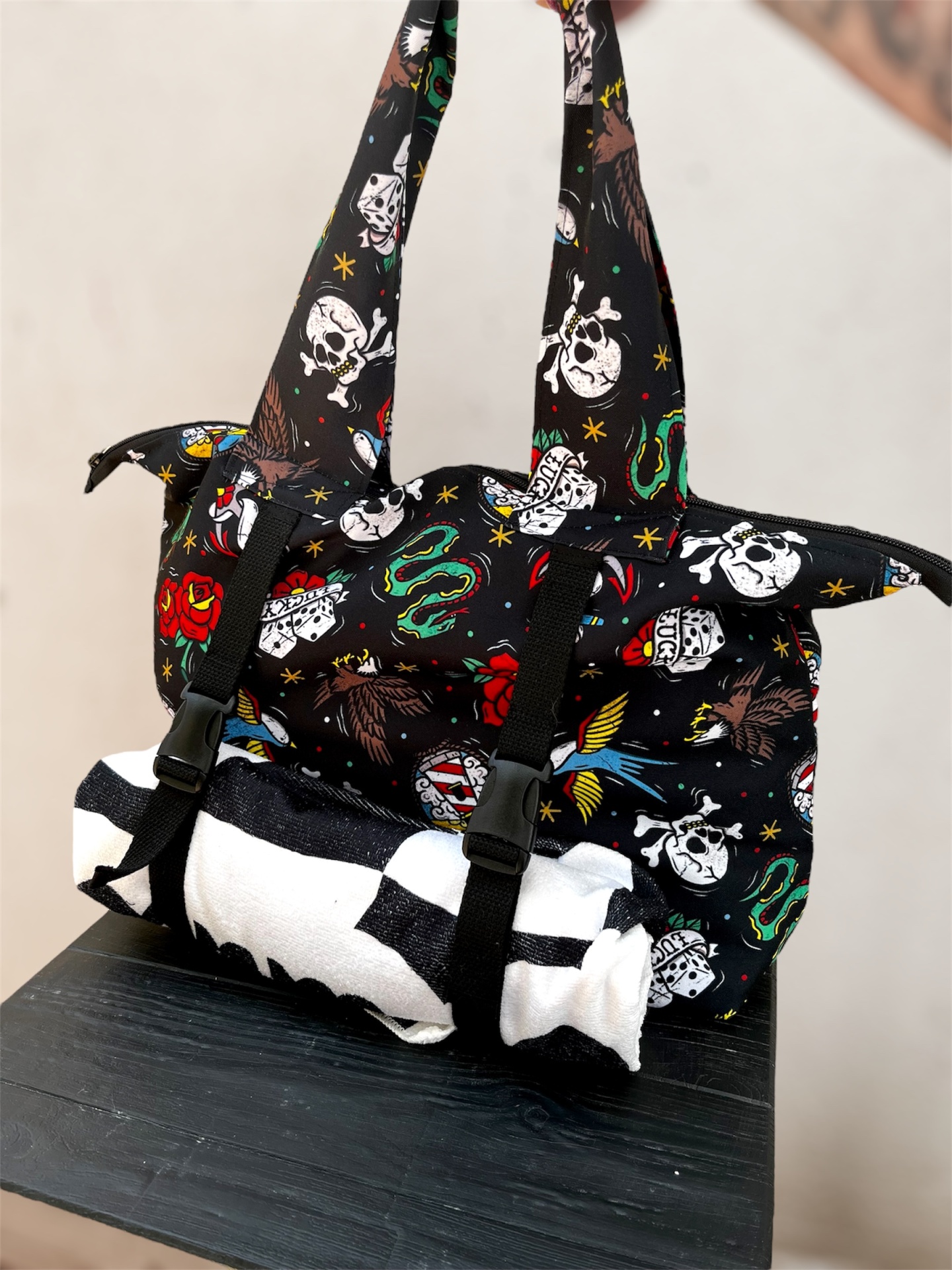 Mala preta com padrão colorido e rolo branco e preto preso