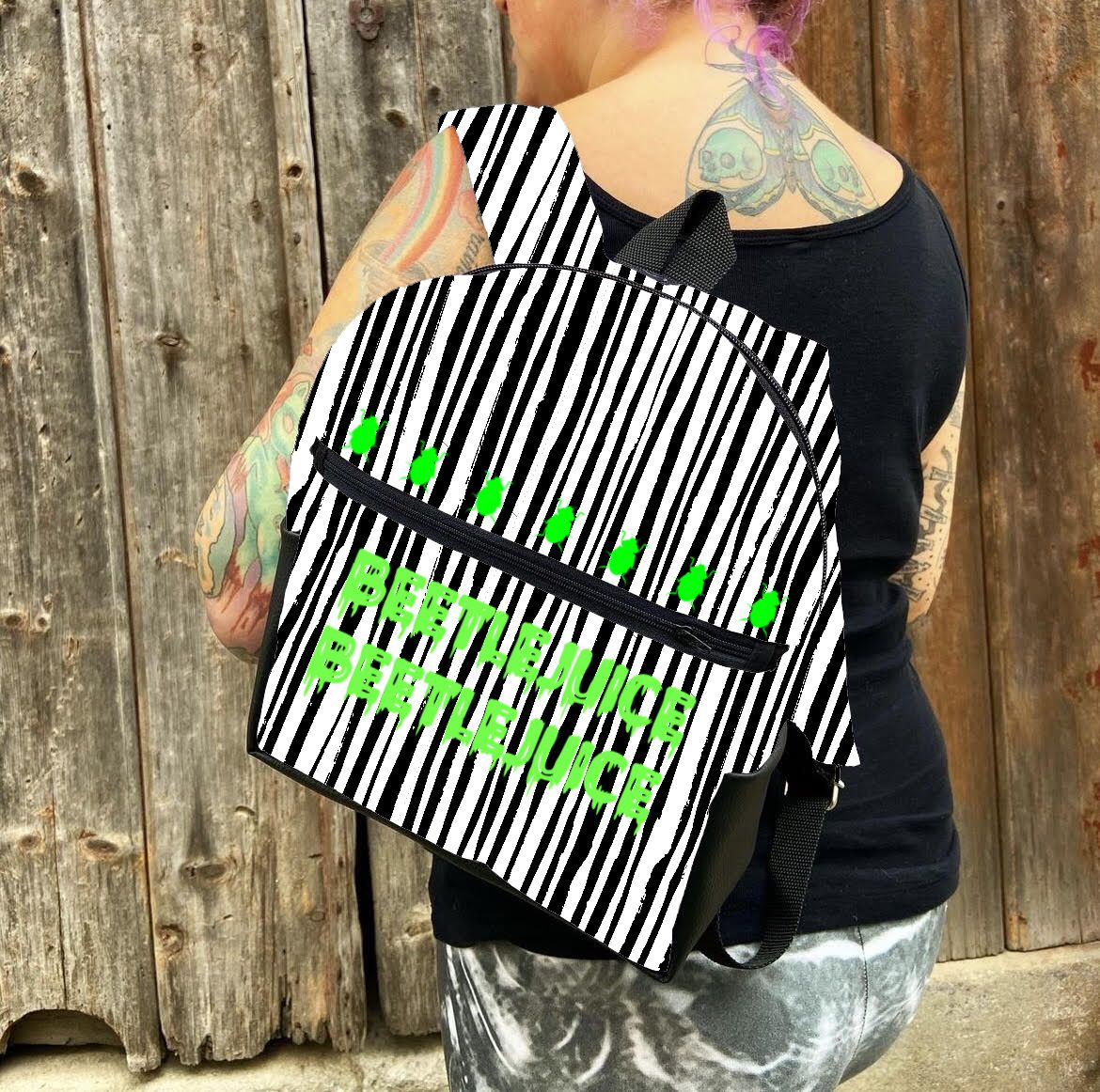 Mochila com riscas pretas e brancas e texto verde BERTHJUICE BERTHJUICE