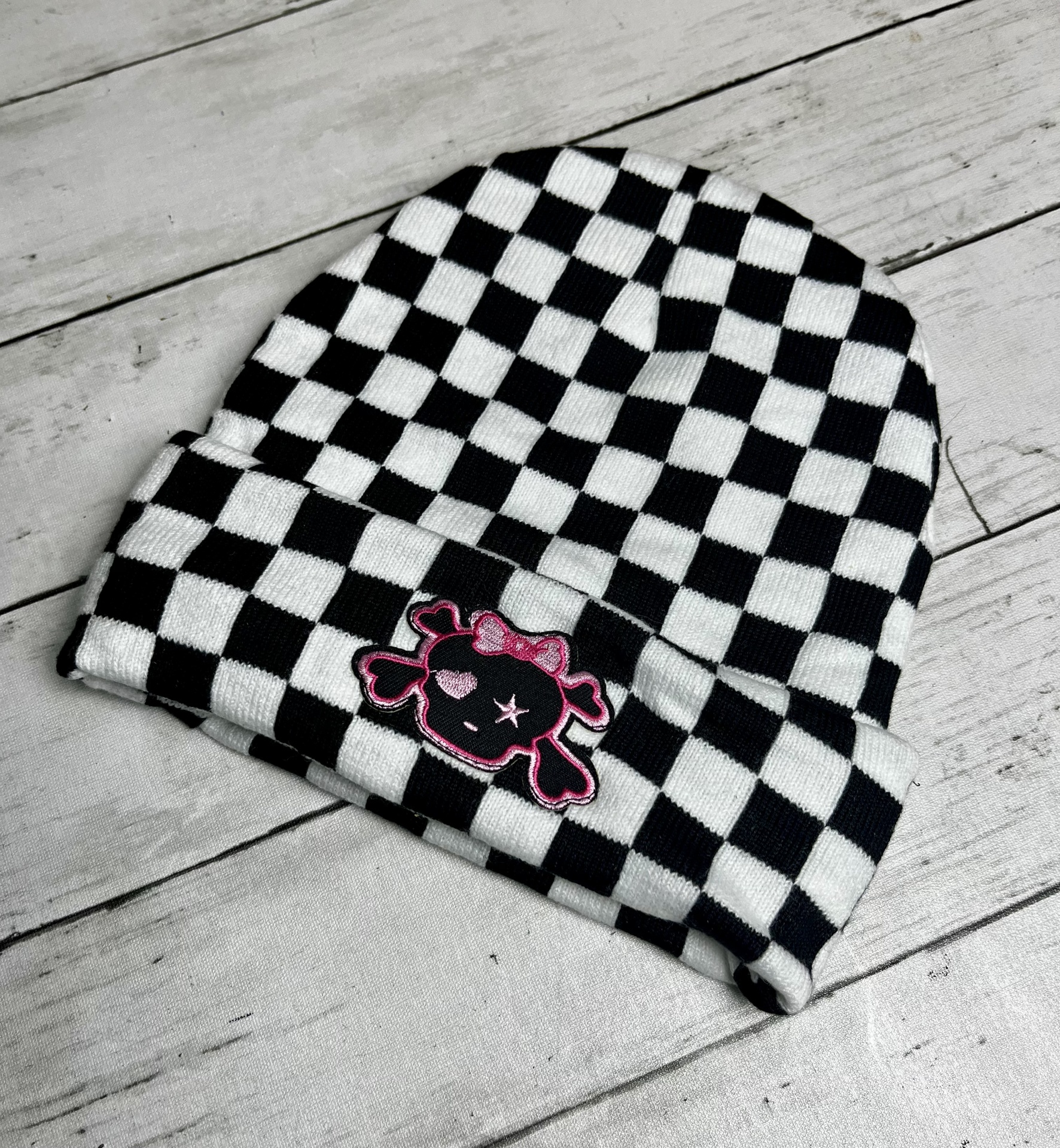 Gorro de tecido preto e branco com caveira cor-de-rosa