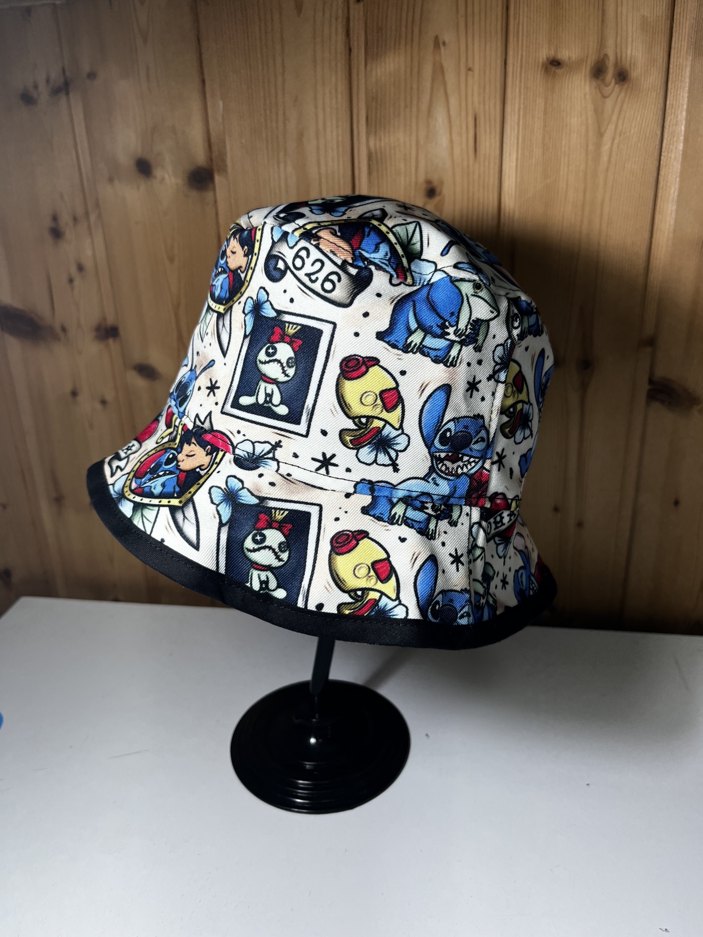 Chapéu bucket branco com estampas coloridas de personagens animados e borda preta na aba.