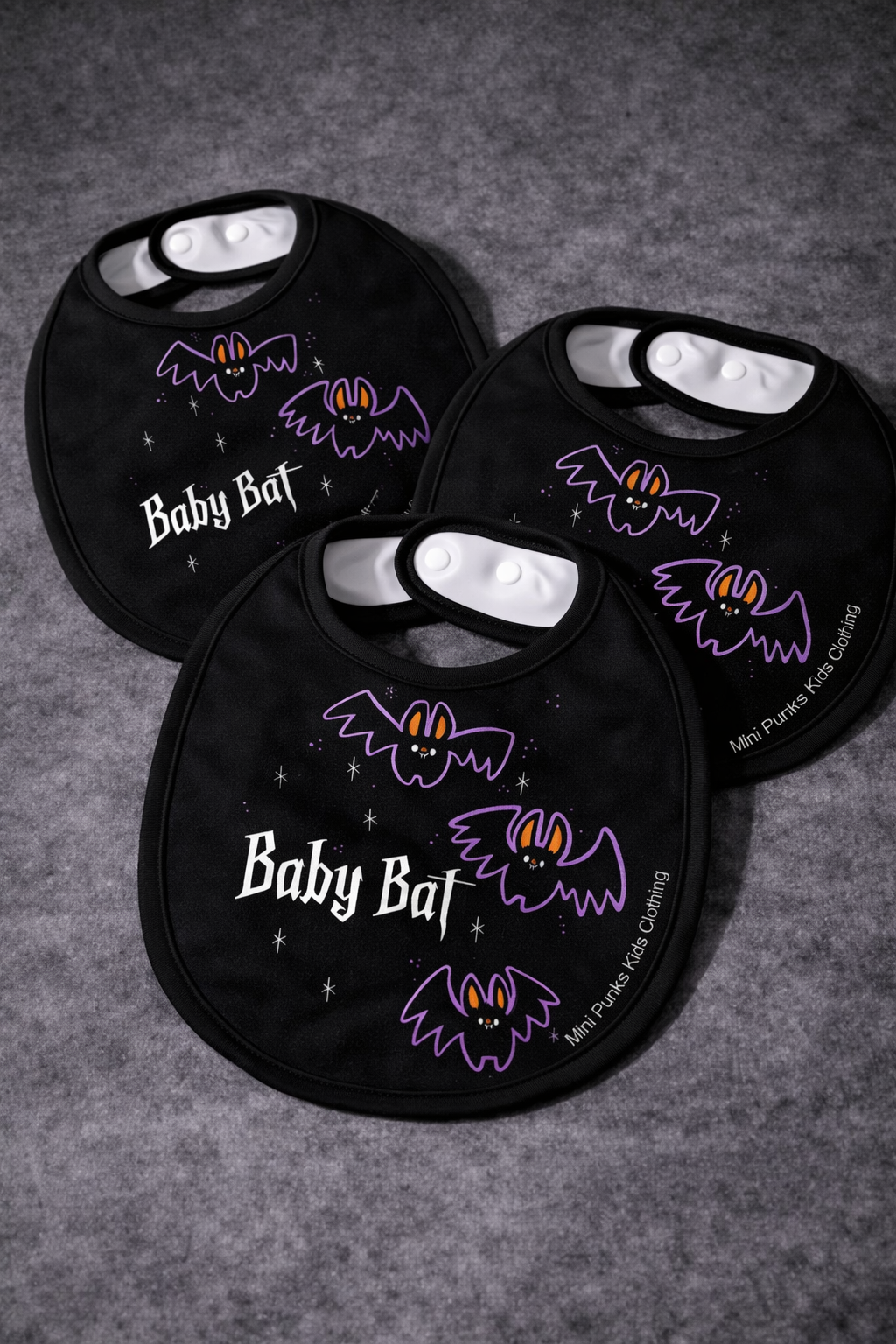 Conjunto de três babetes pretos com morcegos e texto em branco