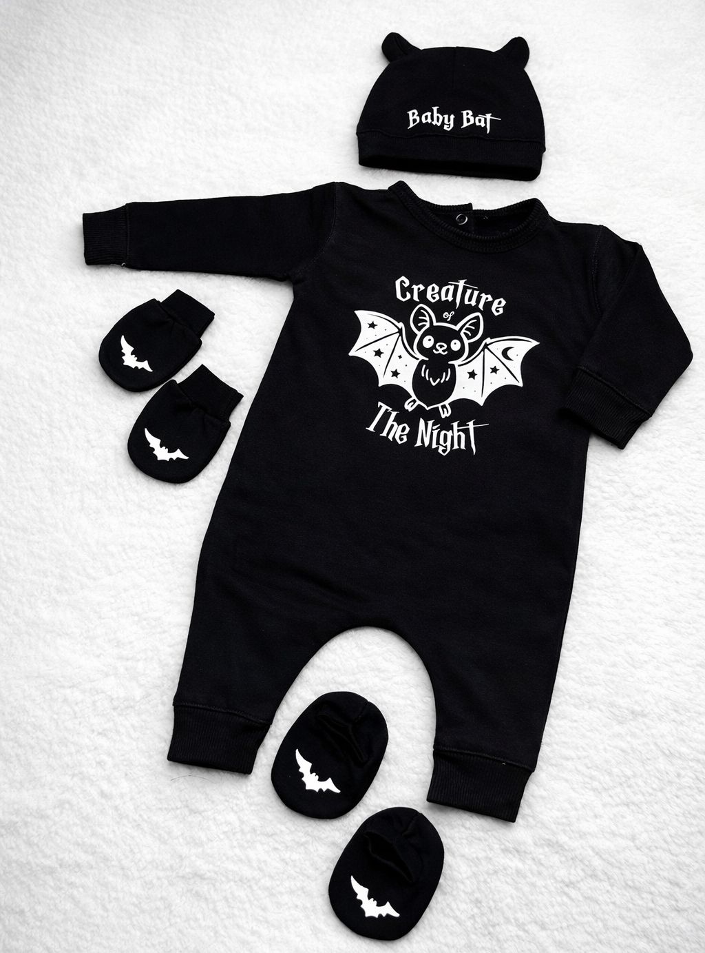 Conjunto de bebé preto com pijama, gorro e luvas com morcegos e texto