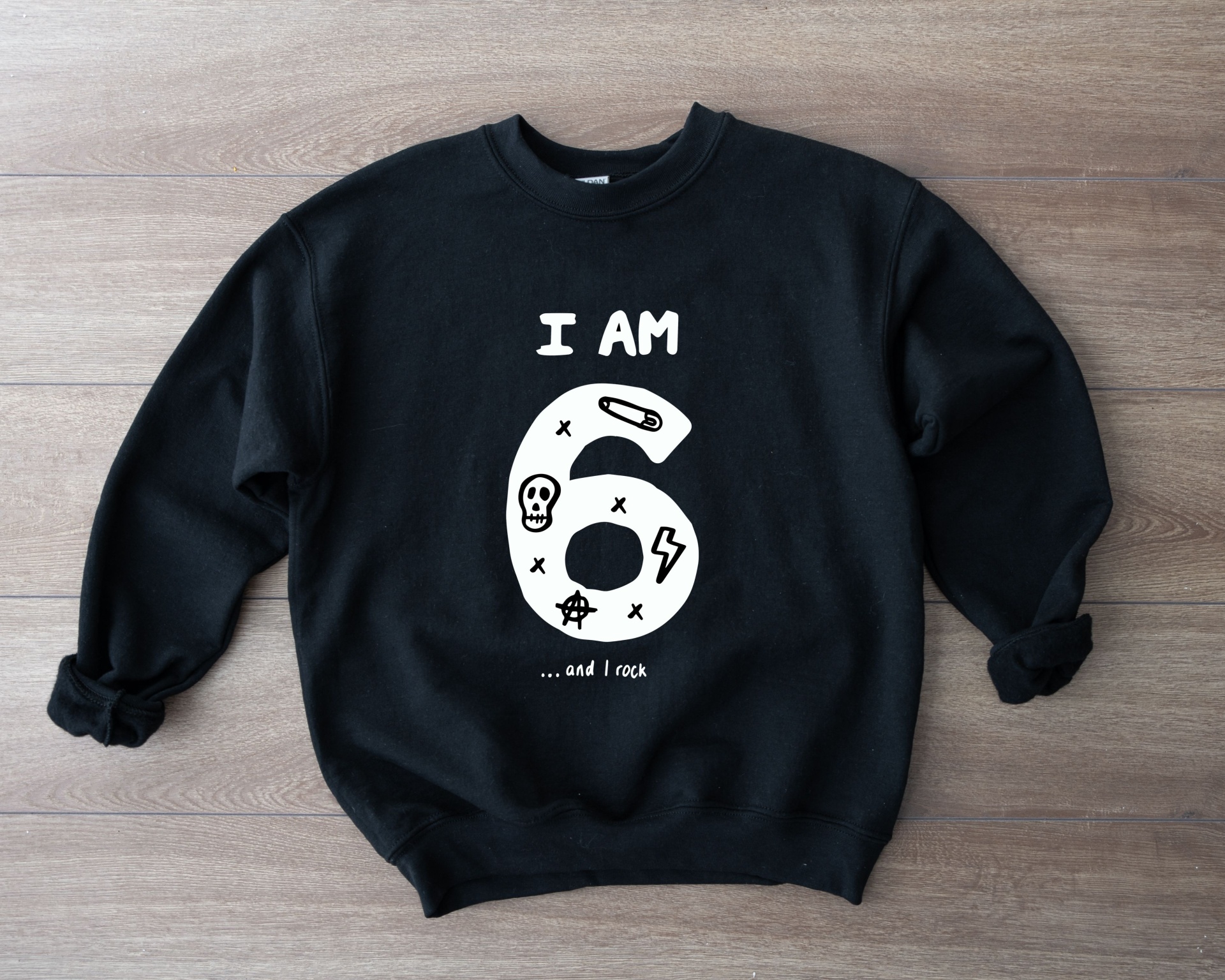 Sweatshirt preta com texto branco I AM 6 ...and I rock em chão de madeira clara