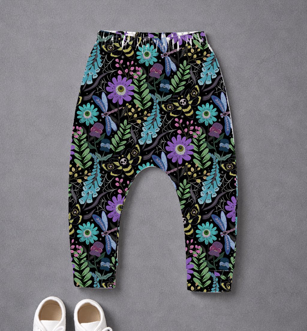 Calças de bebé com padrão colorido de flores e insetos sobre fundo preto