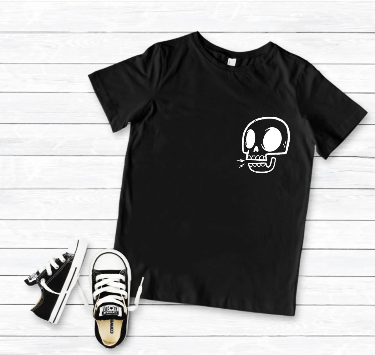 Camiseta preta com estampa de crânio branco e sapatilhas pretas com atacadores brancos