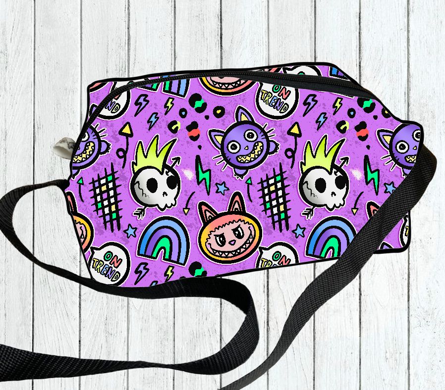 Bolsa tiracolo lilás com padrões coloridos de crânios e arcos-íris